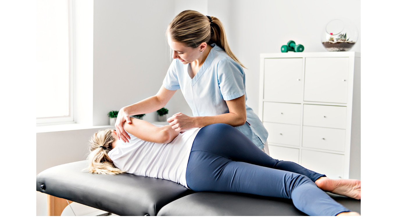 A healthcare professional performing a physical therapy assessment or treatment on a patient lying on an examination table. The setting is bright with natural light and medical storage in the background.