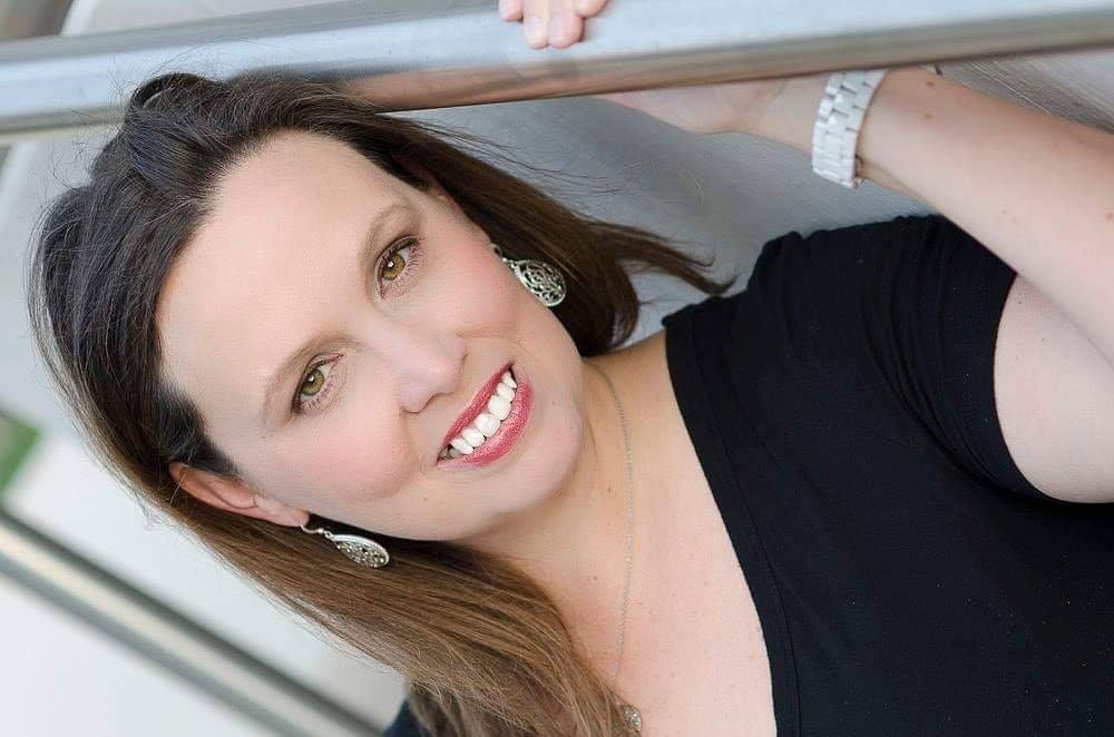 A woman leaning against a handrail.
