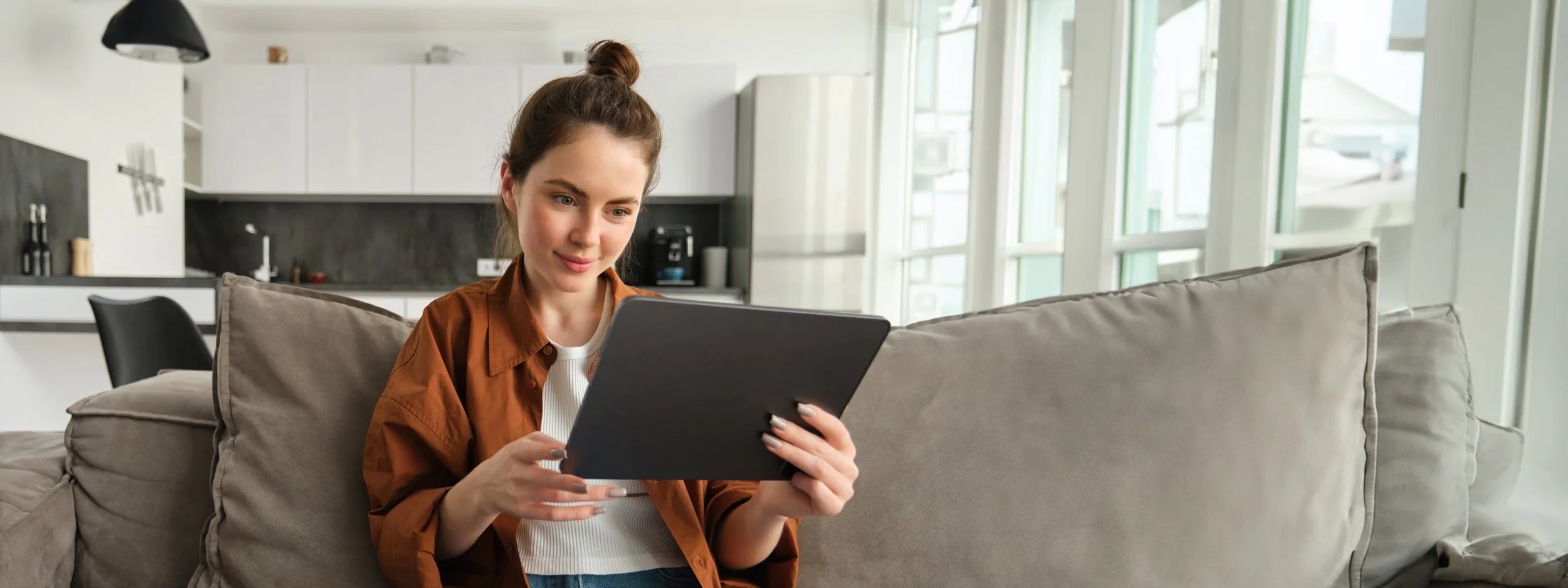 portrait-smiling-beautiful-woman-sitting-couch-watching-videos-digital-tablet-reading-ebook.jpg