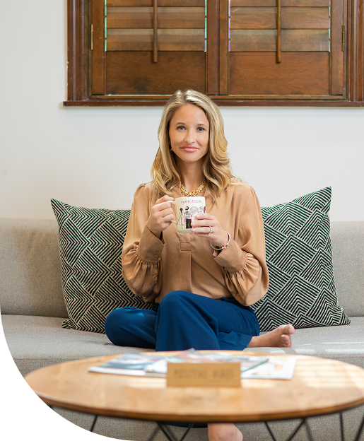 Theresa Peterson sitting with a mug in a cozy living room, symbolizing clear, confident retirement and income-planning conversations.