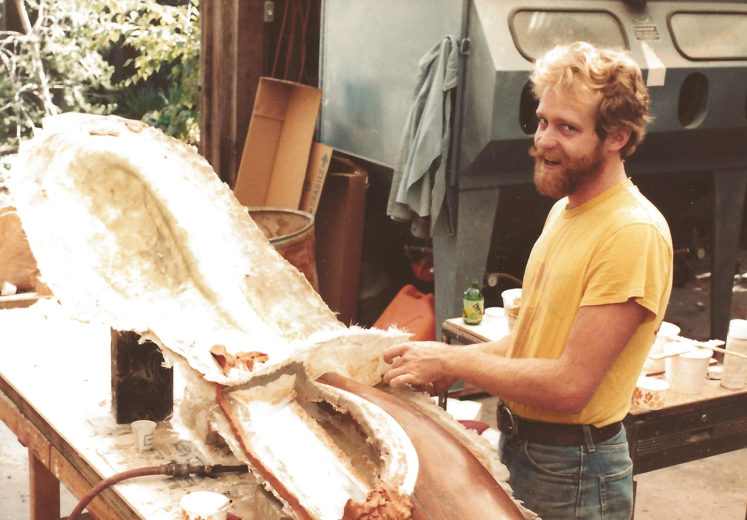T Barny applying fiber glass to a sculpture mold