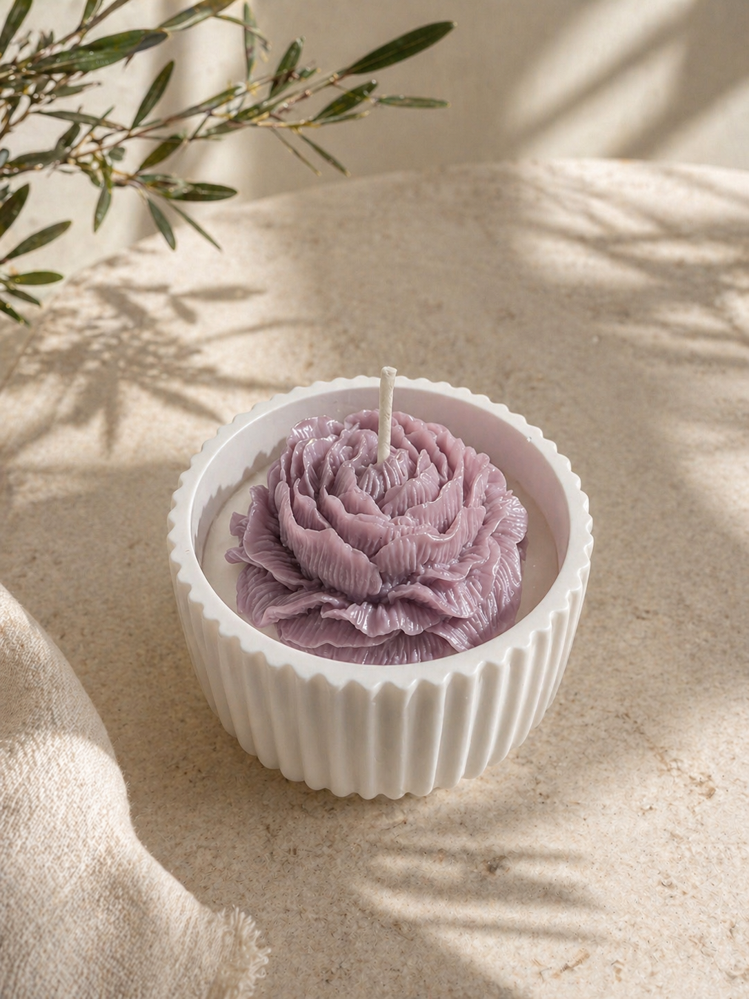 Luxury Bloom Vessel Candle with lavender mauve floral wax center in white ceramic jar photographed in natural sunlight.