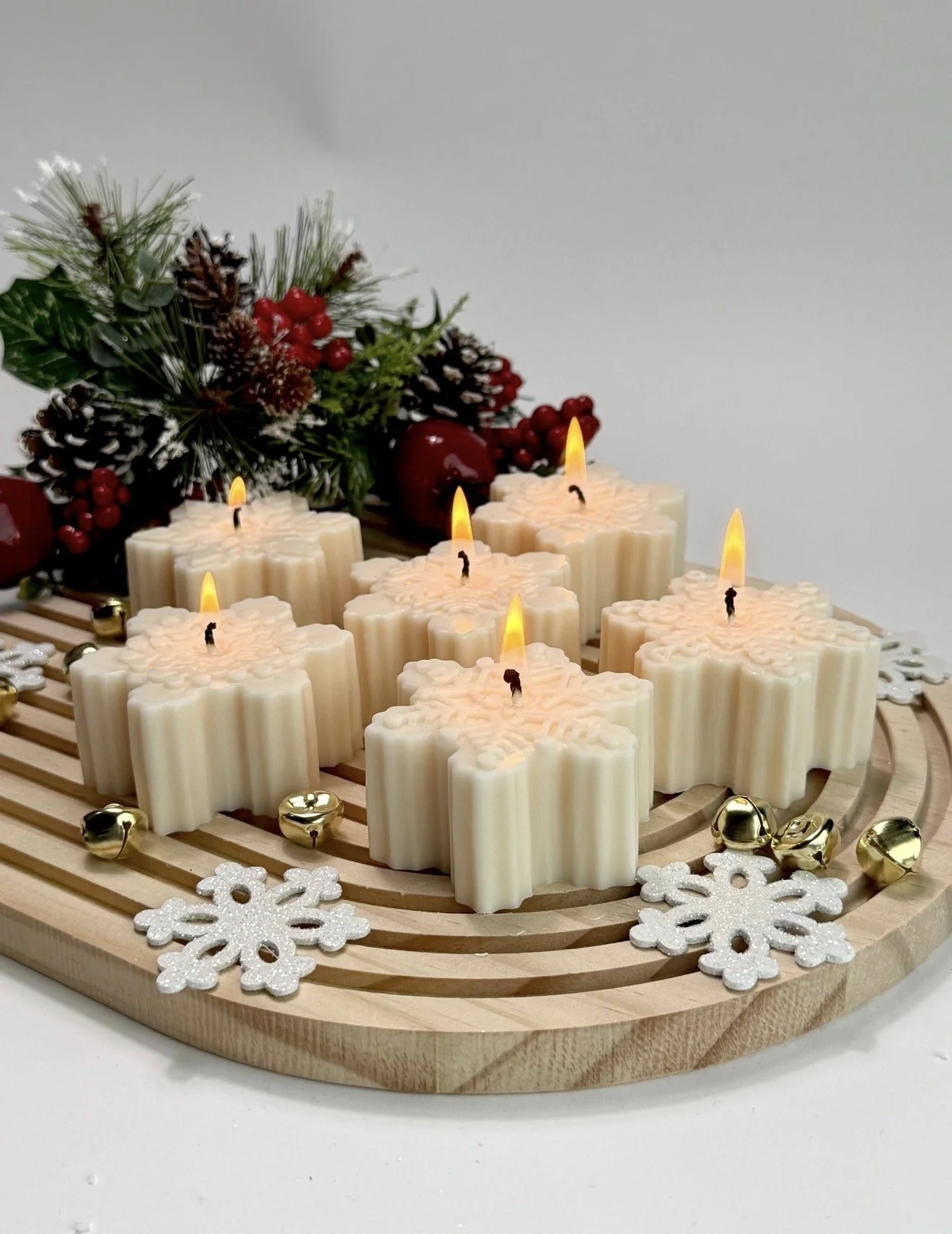 Handcrafted snowflake soy candles with holiday decorations and pine greenery, festive Christmas candle decor by Candle Club Company in Connecticut.