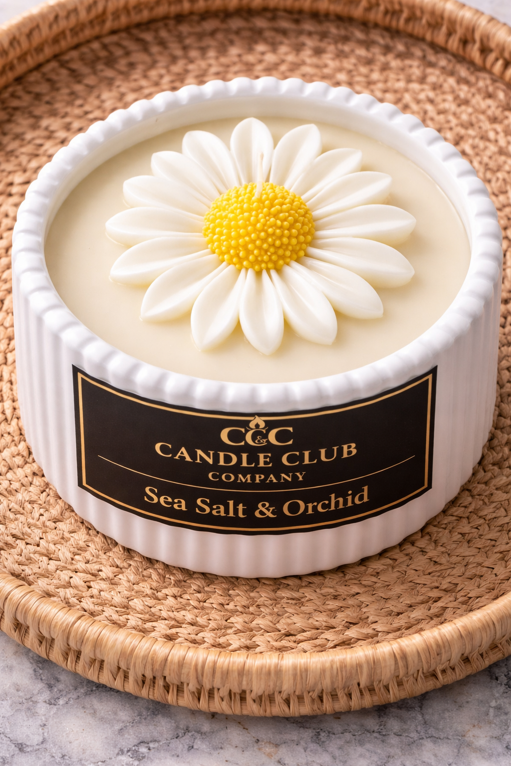 Top view of daisy flower soy candle with white petals and yellow center in ceramic vessel
