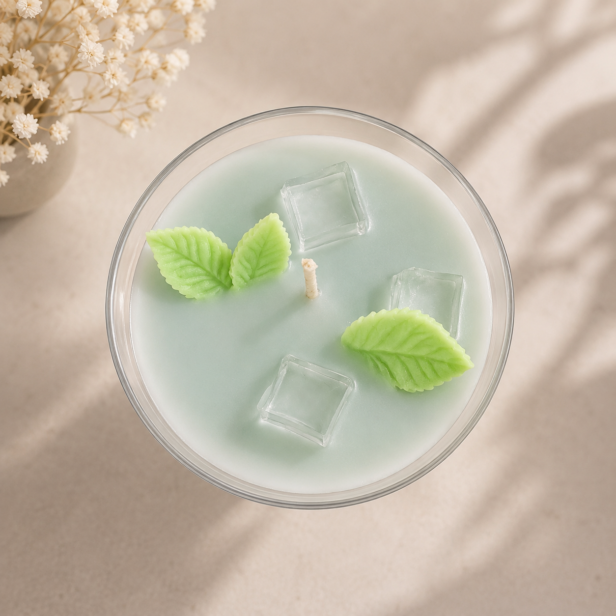 Top view of Mint Mojito Martini luxury candle with mint wax embeds and clear ice cube accents in a martini glass.