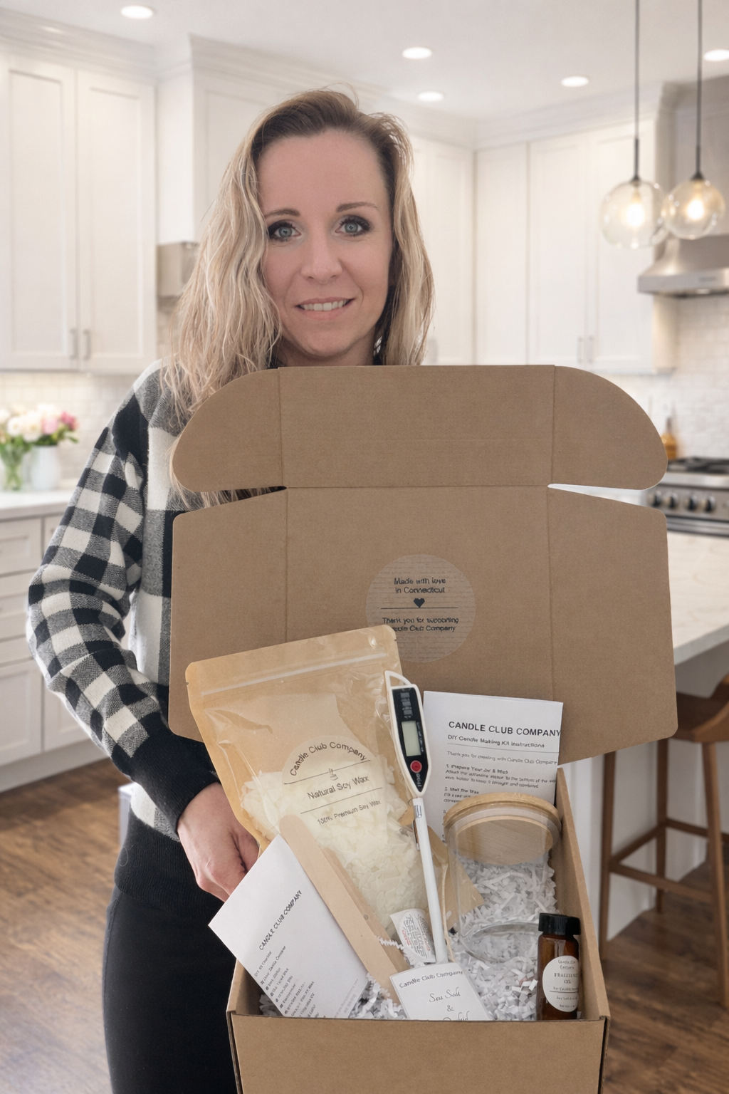 Founder of Candle Club Company in Connecticut holding a DIY candle making kit and luxury handmade soy candle subscription box.