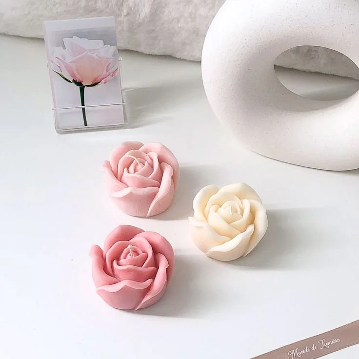 Handcrafted pink and white rose-shaped wax flowers displayed on a white surface with neutral home decor, styled by Candle Club Company in Connecticut