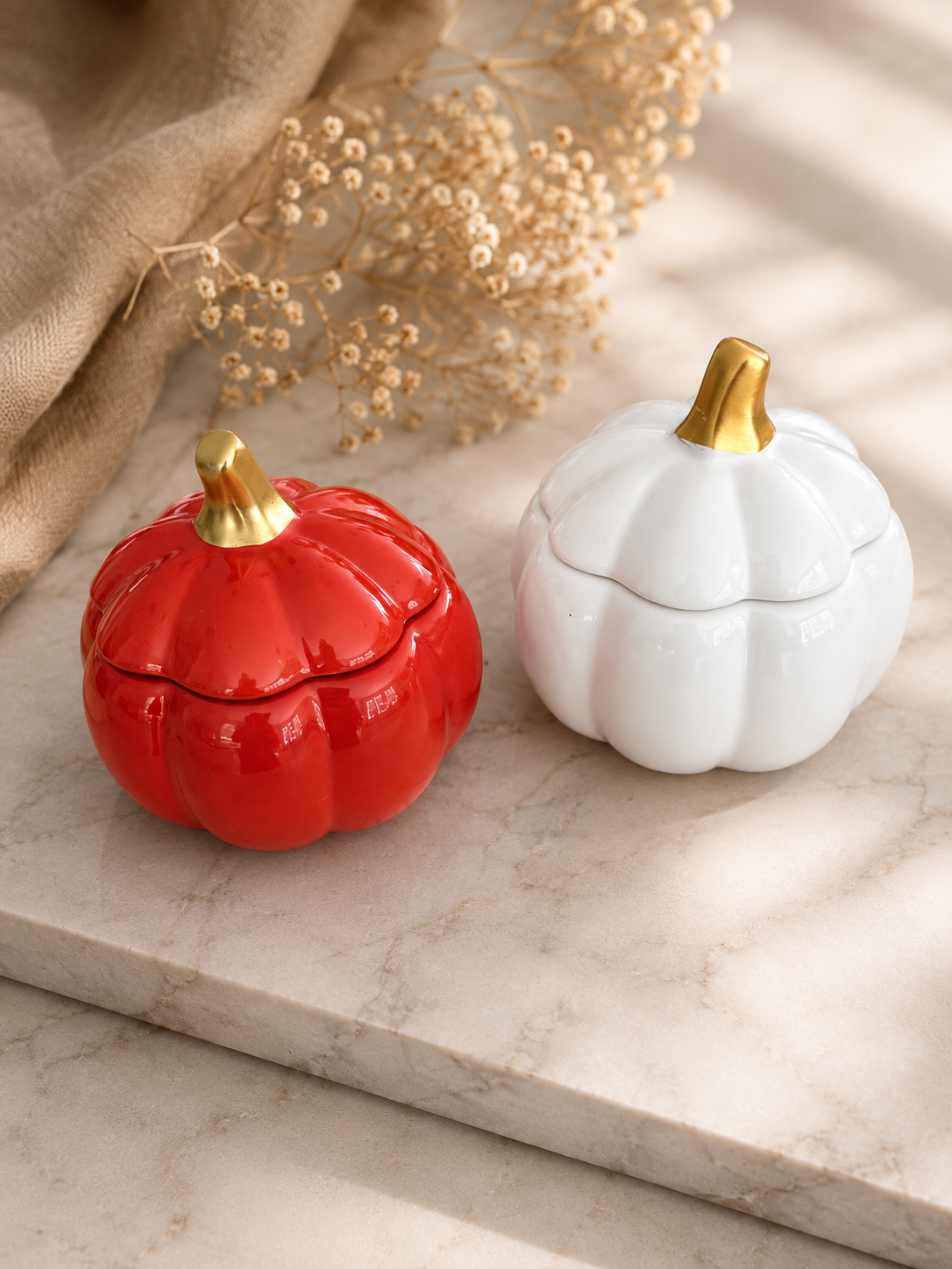 Orange and white ceramic pumpkin soy candles with elegant gold stems, handmade and hand-poured in Farmington, Connecticut.