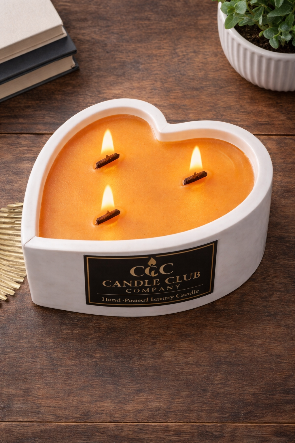 heart shaped triple wick candle on wooden table with luxury label and soft lighting