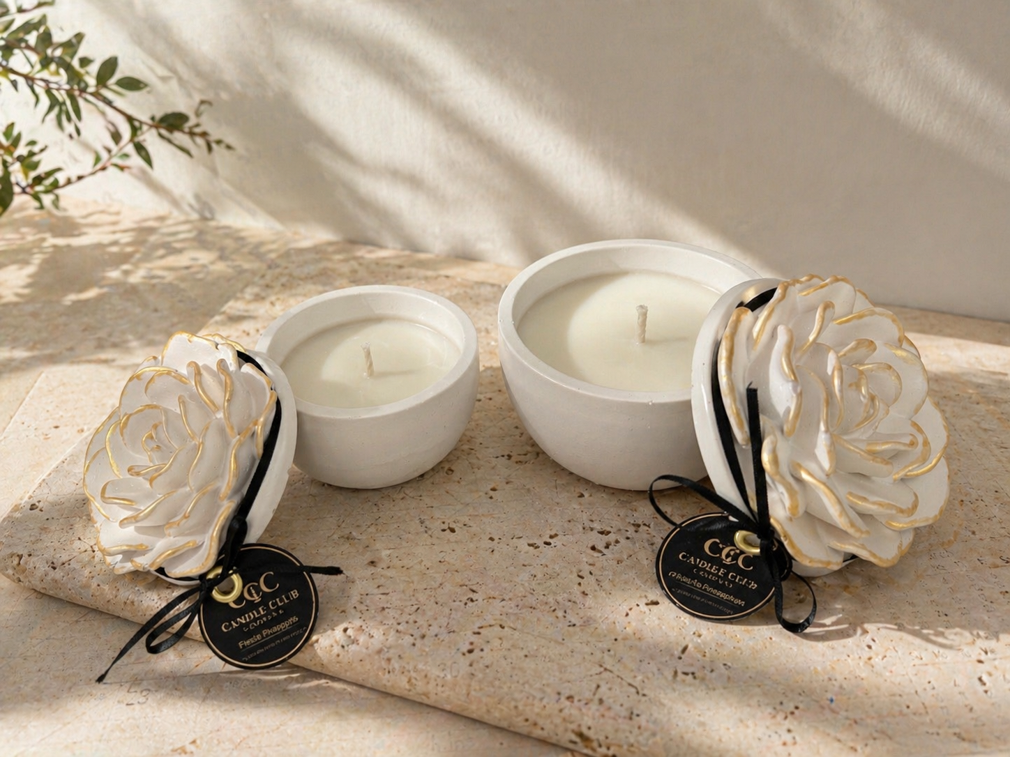 Open floral vessel soy candles showing smooth wax and decorative flower lids on stone surface with soft sunlight.