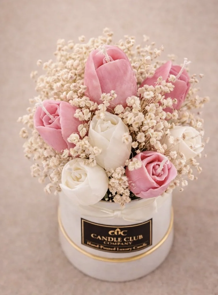 Top view of handmade tulip candle bouquet with pink and white wax flowers and delicate dried florals in a luxury ceramic container