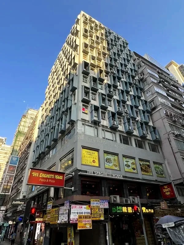 A tall urban building with a distinctive exterior pattern of protruding and recessed windows. Metropole Building in Tsim Sha Tsui, Hong Kong