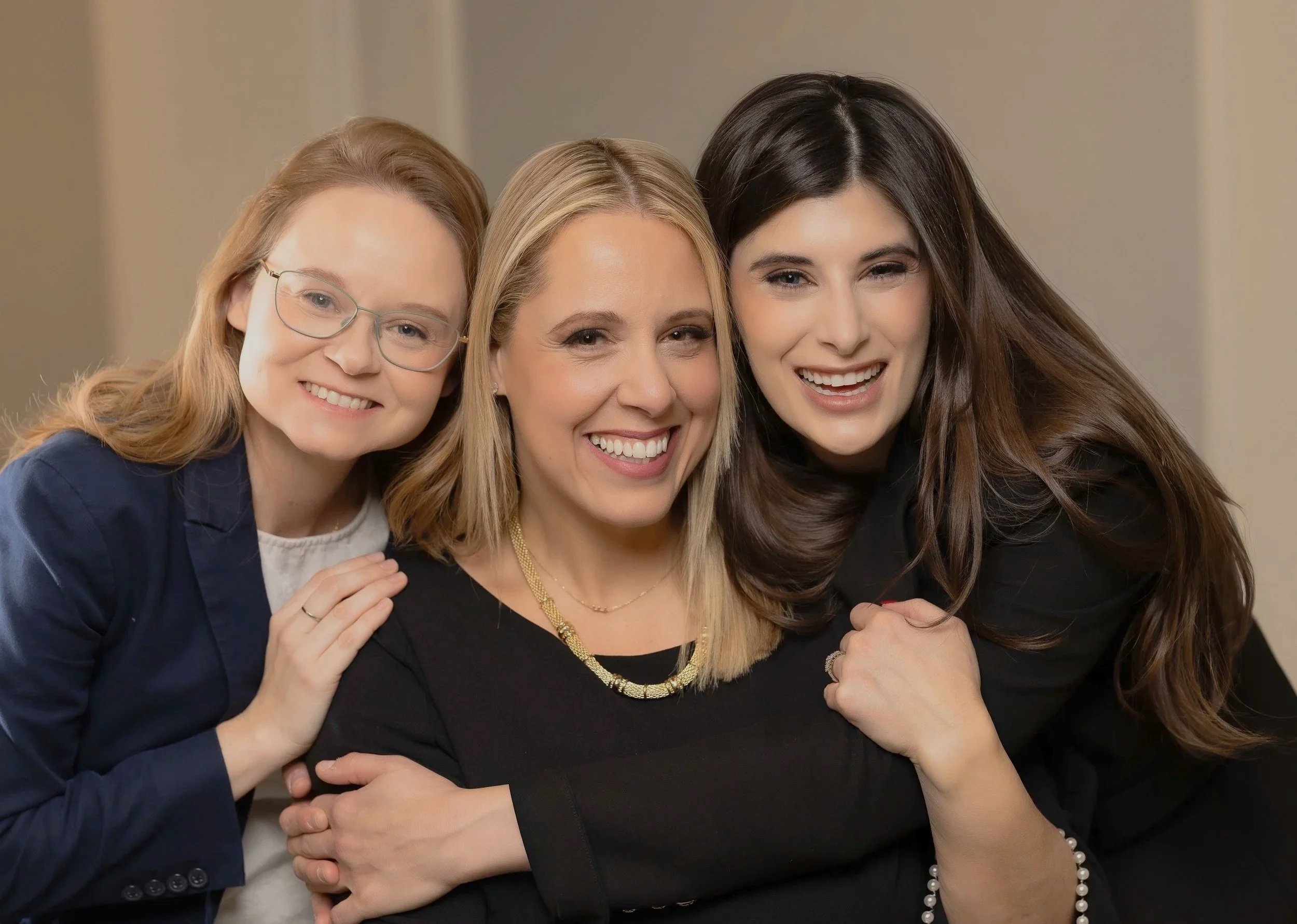 A woman with curly hair in a black sleeveless shirt that says 'Boston Peloton' stands at a reception desk, looking at her phone, inside a Peloton store.