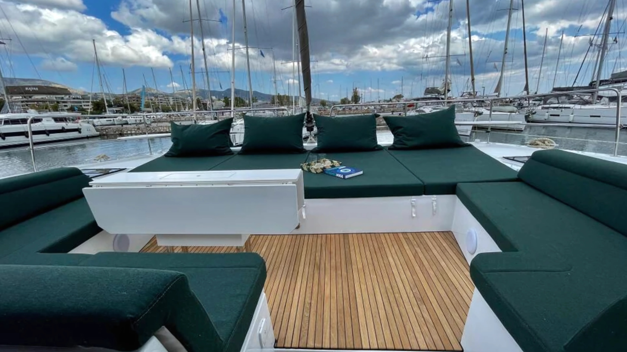 luxury yacht deck with green seating, marina in background