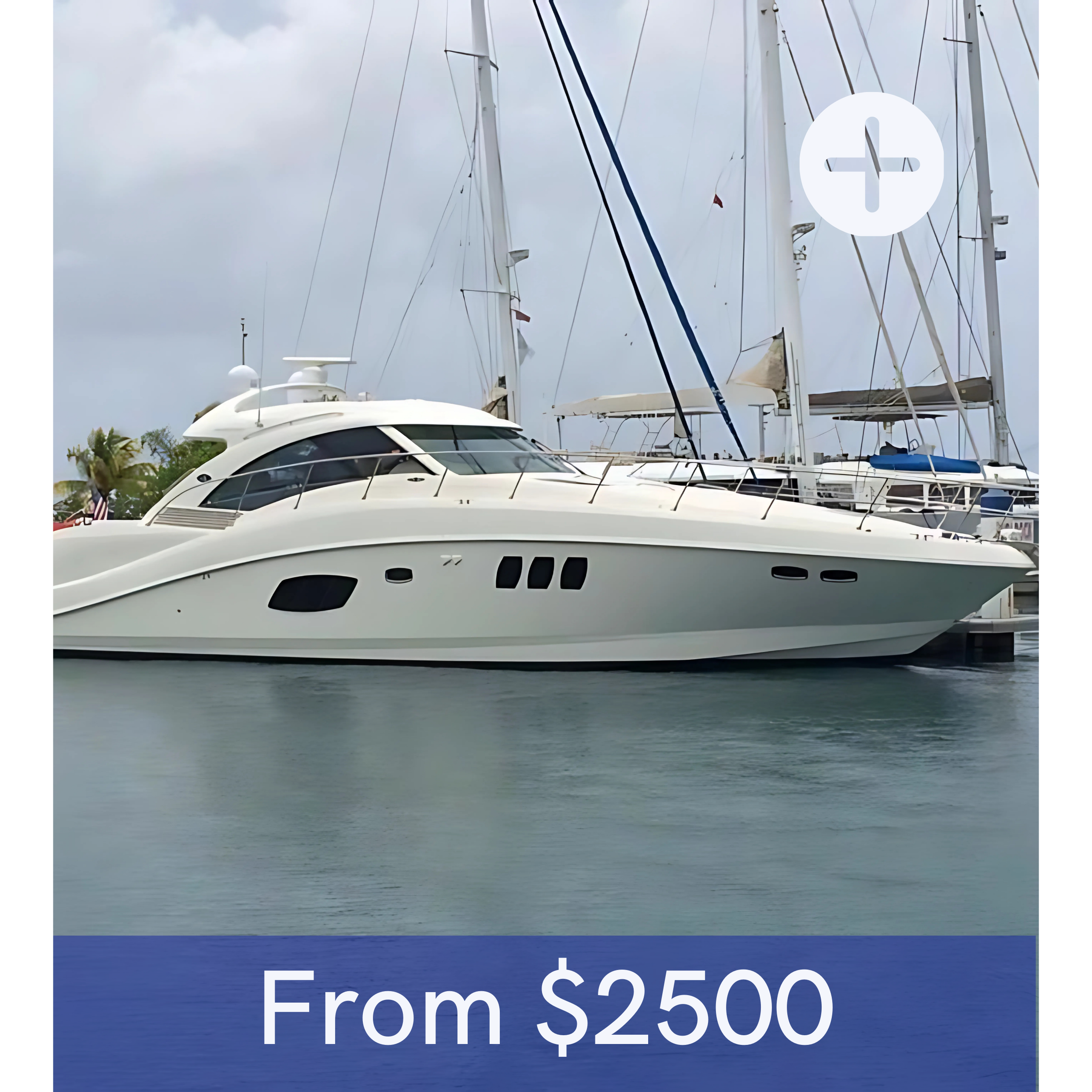A white luxury yacht docked at a marina with sailboats in the background.
