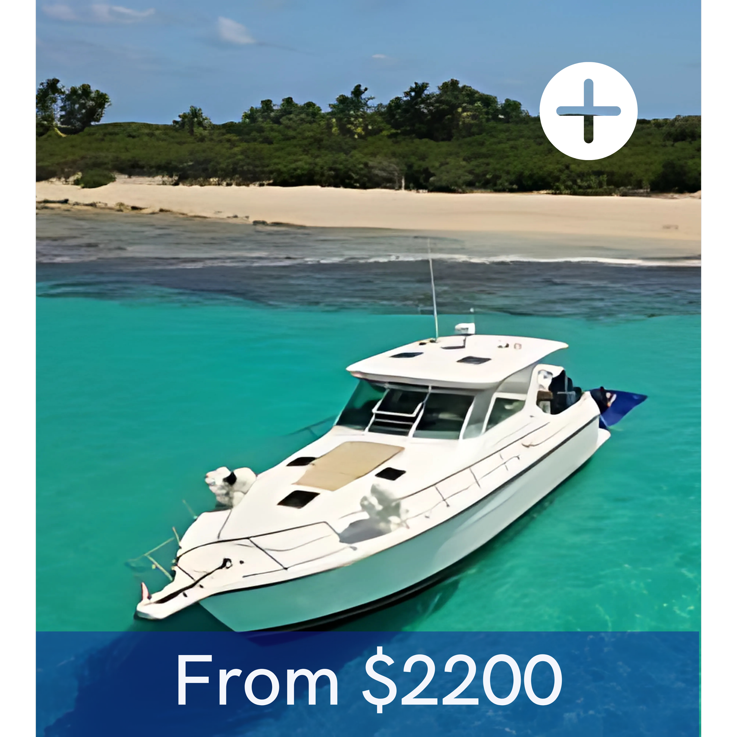 A white yacht floating on clear turquoise water near a beach with green trees and a blue sky.