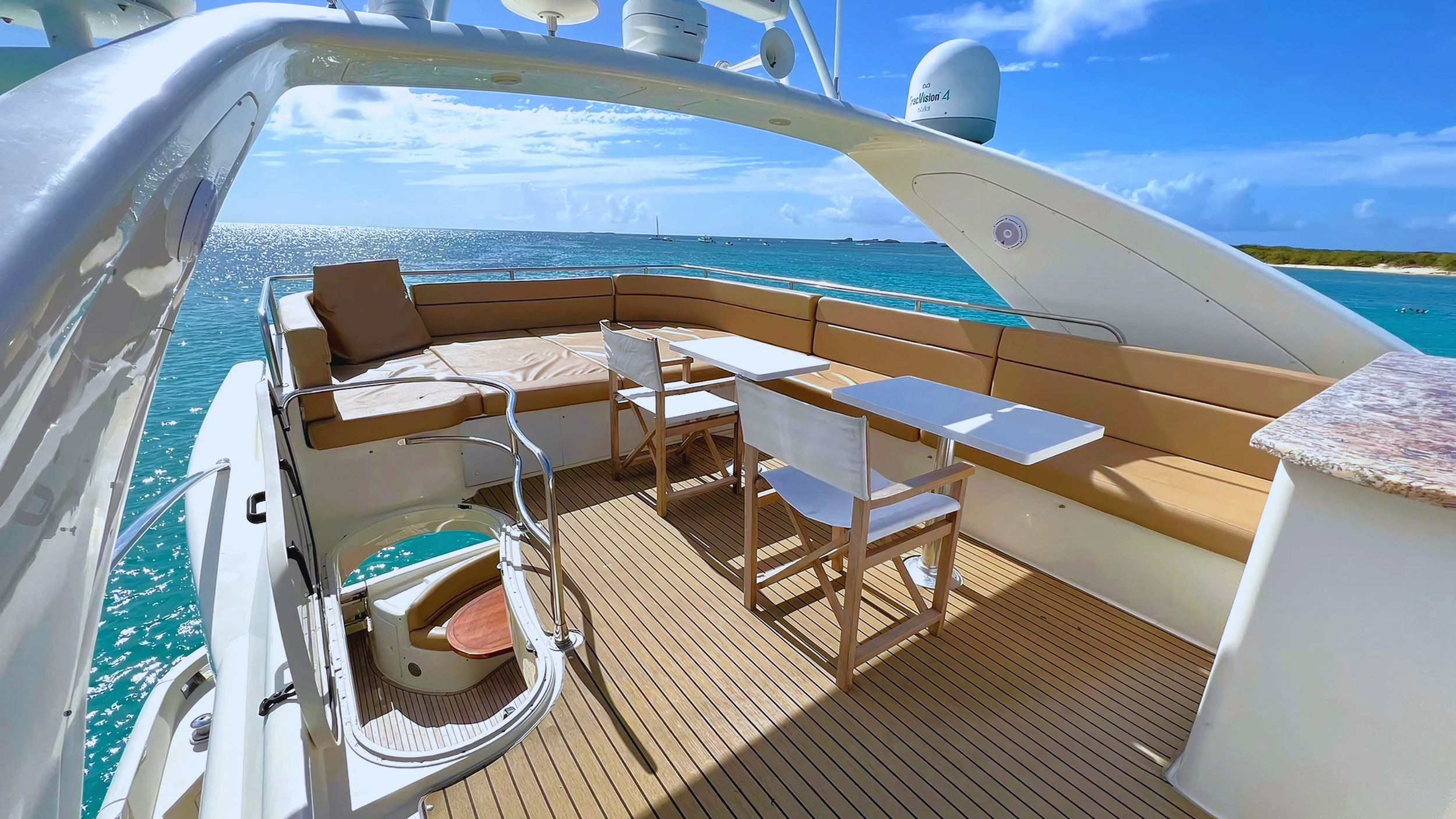 Luxury yacht deck with seating area, tables, and ocean view.