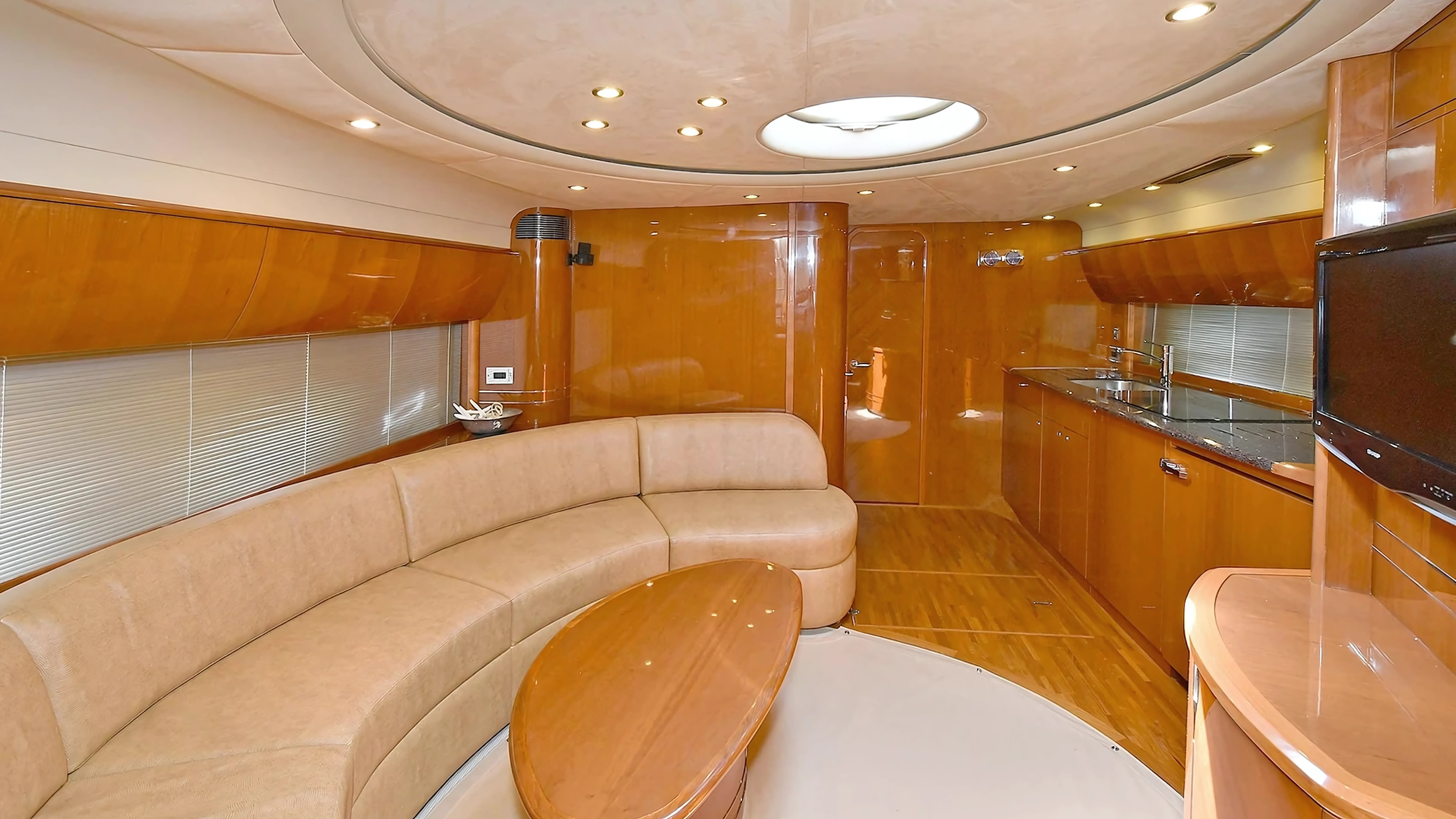 luxury yacht interior with beige leather seating, wood paneling, and modern kitchen