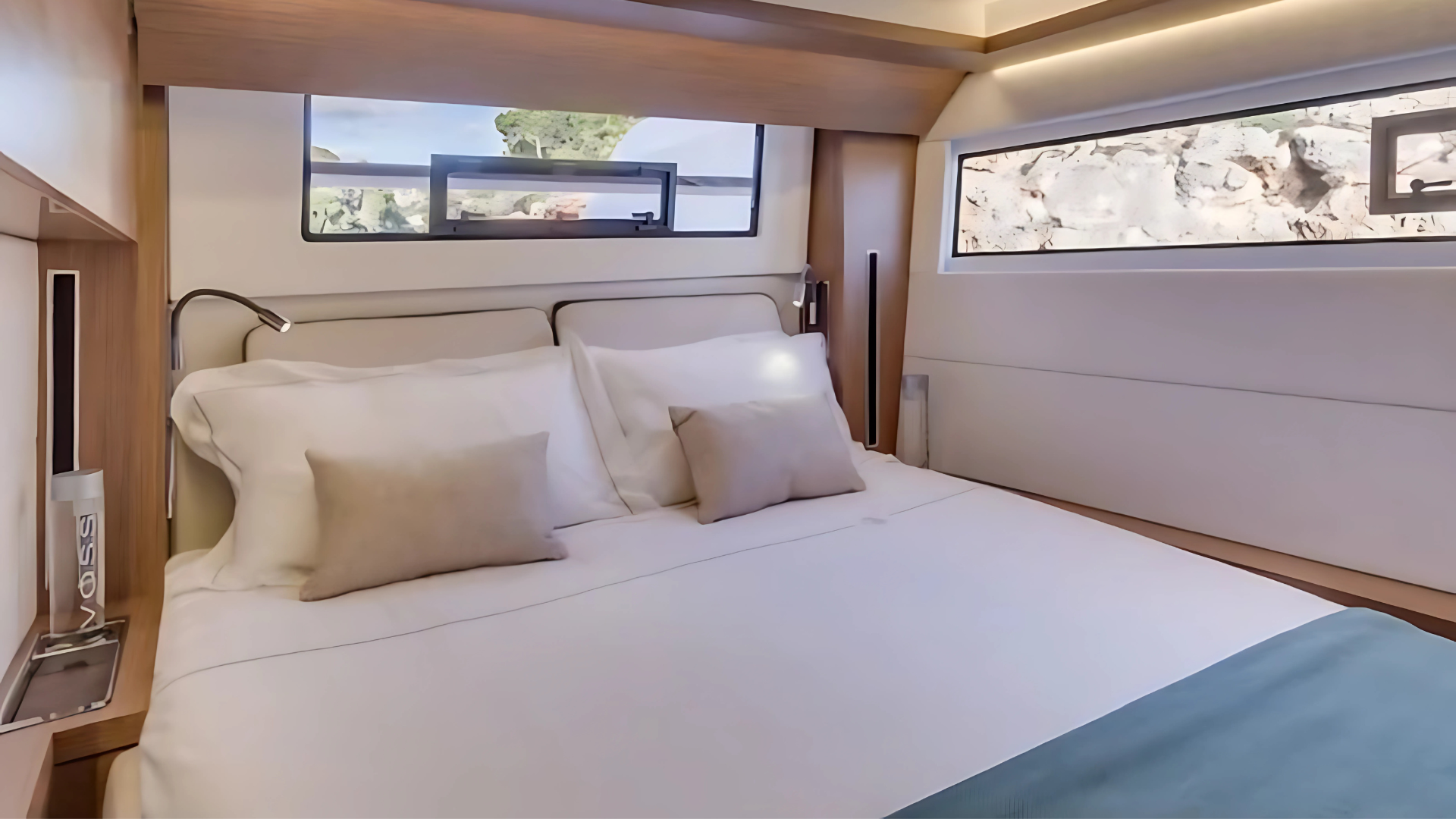 Modern yacht bedroom with white bedding, two pillows, and panoramic windows.