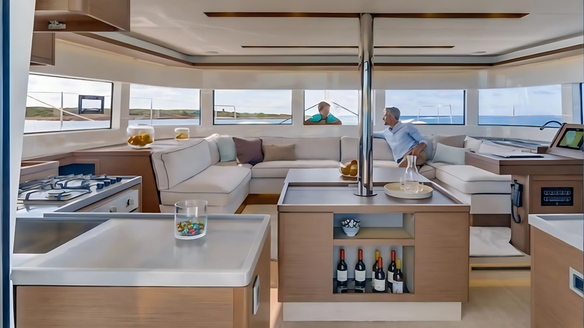 Luxury yacht interior with modern kitchen and lounge, featuring couches, panoramic windows, and ocean view.