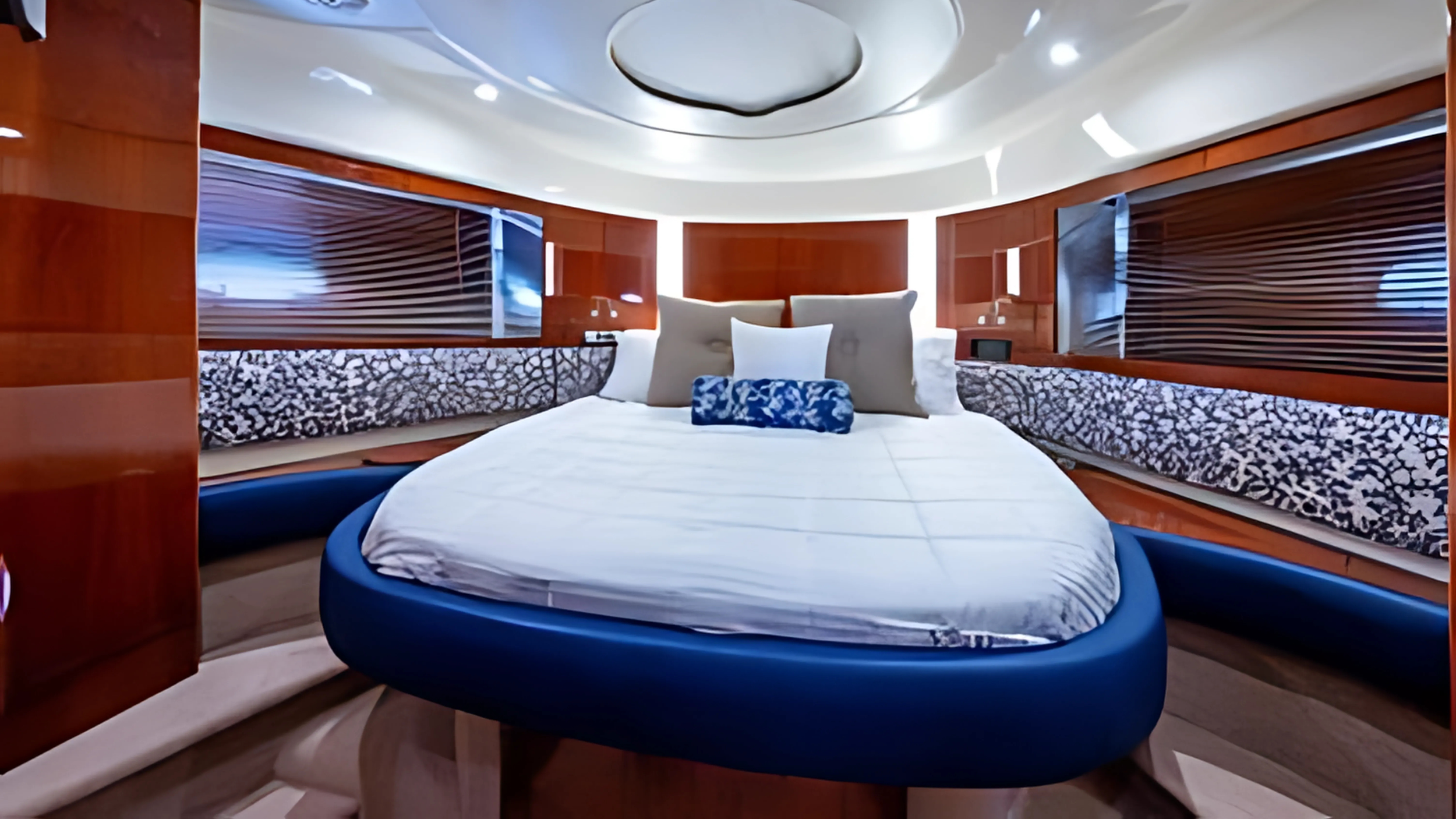 A modern, round bed with a white comforter and several pillows, set in a stylish bedroom with wooden paneling and decorative lighting.