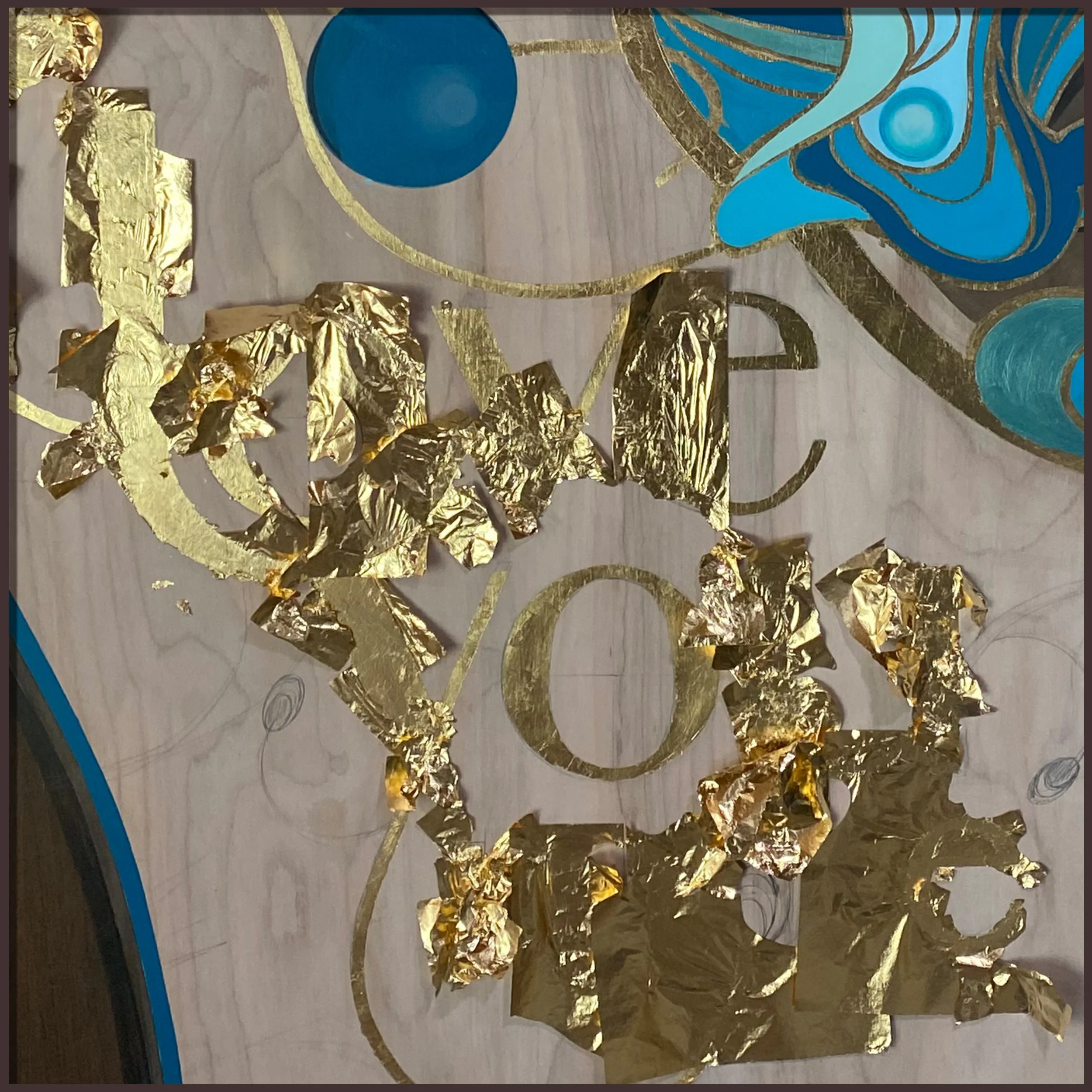Artist hand-applying 24k gold leaf to butterfly wing on wood painting
