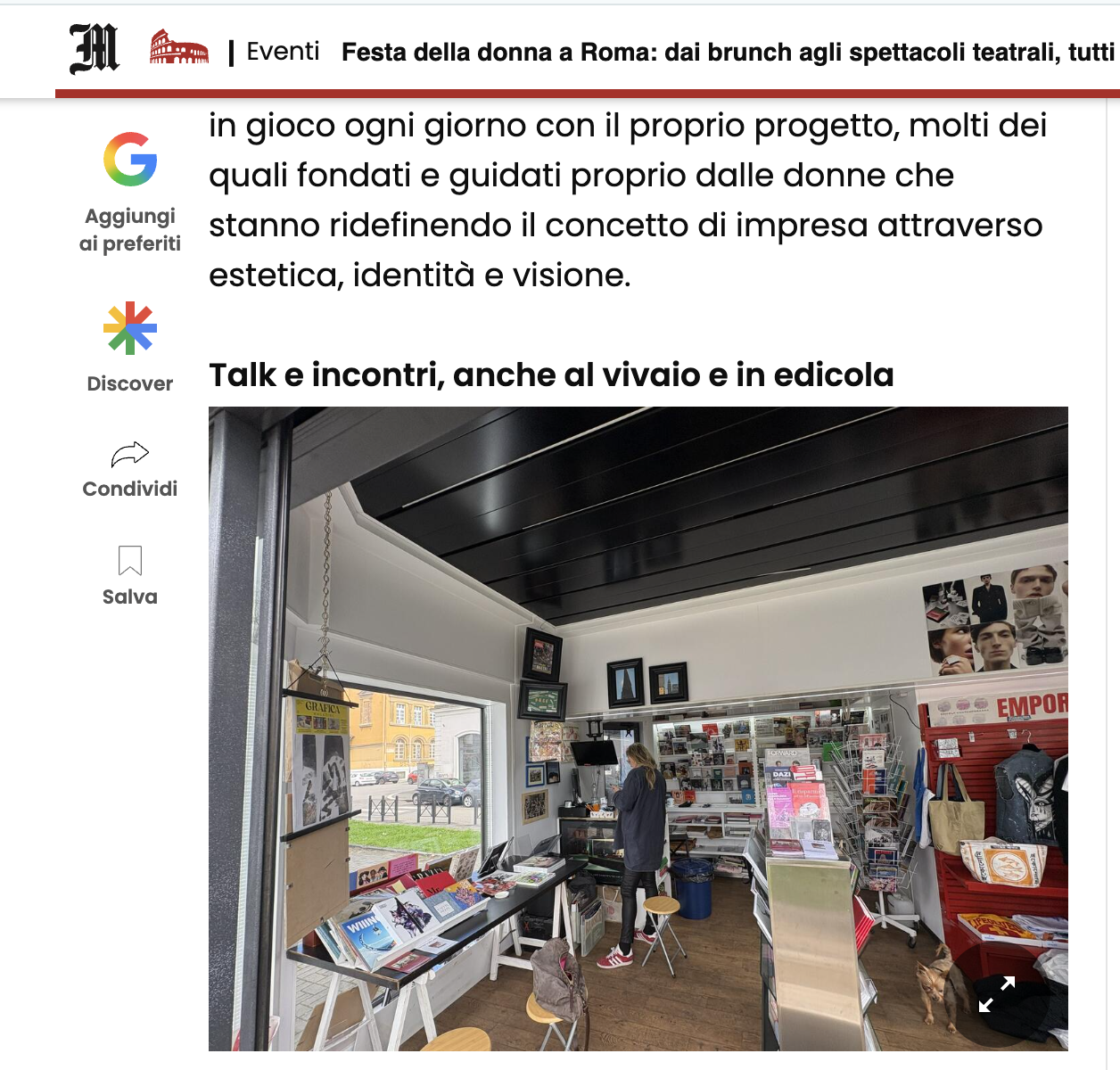 Interno di una libreria con scaffali di libri, una donna che legge, e un cane in un angolo, con pareti decorate e finestre che mostrano edifici urbani esterni.