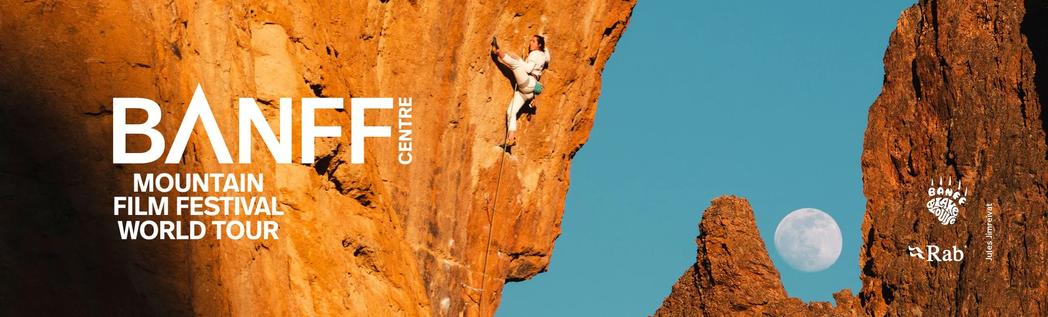 An outdoor scene featuring two rock climbers on a dark mountain, under a starry night sky with the Milky Way visible. Text on the image advertises the Banff Mountain Film Festival World Tour at Kelowna Community Theatre on December 27-28 at 6:30 pm, showcasing the world's best mountain films. Logos of sponsors and partners are at the bottom.