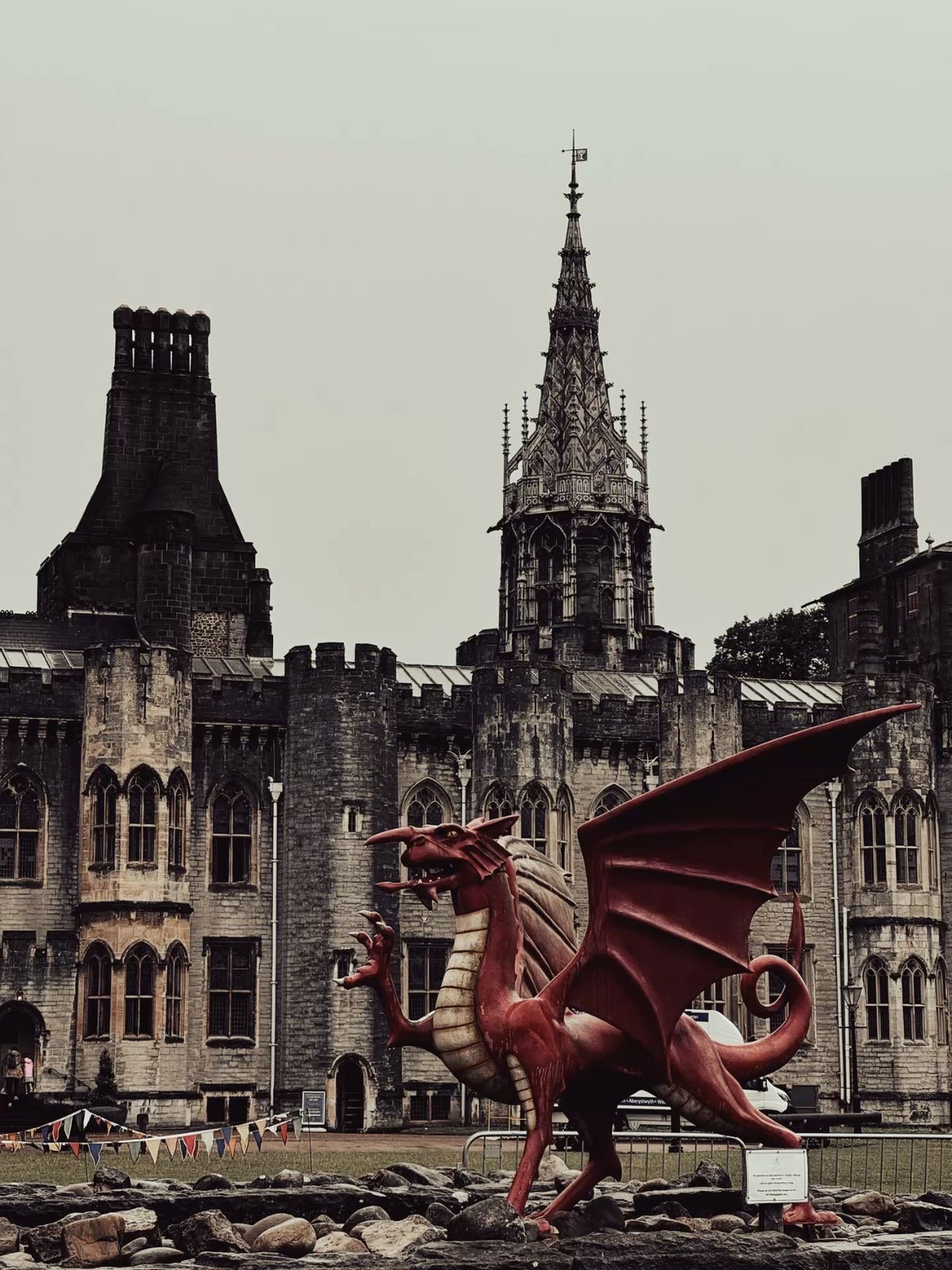 Group of children and adults posing with arms raised in front of a historic stone castle on a sunny trip-day at Hereford UK - Our Camp English Language Summer Camp