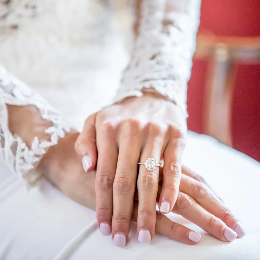 A close up of a bride's hand with her wedding ring in focus by Defining Moments Special Events