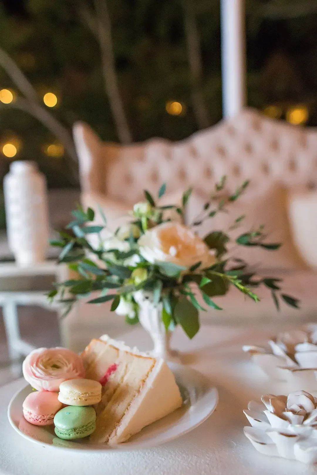 Elegant table setting with a slice of wedding cake and assortment of macaroons by Defining Moments Special Events