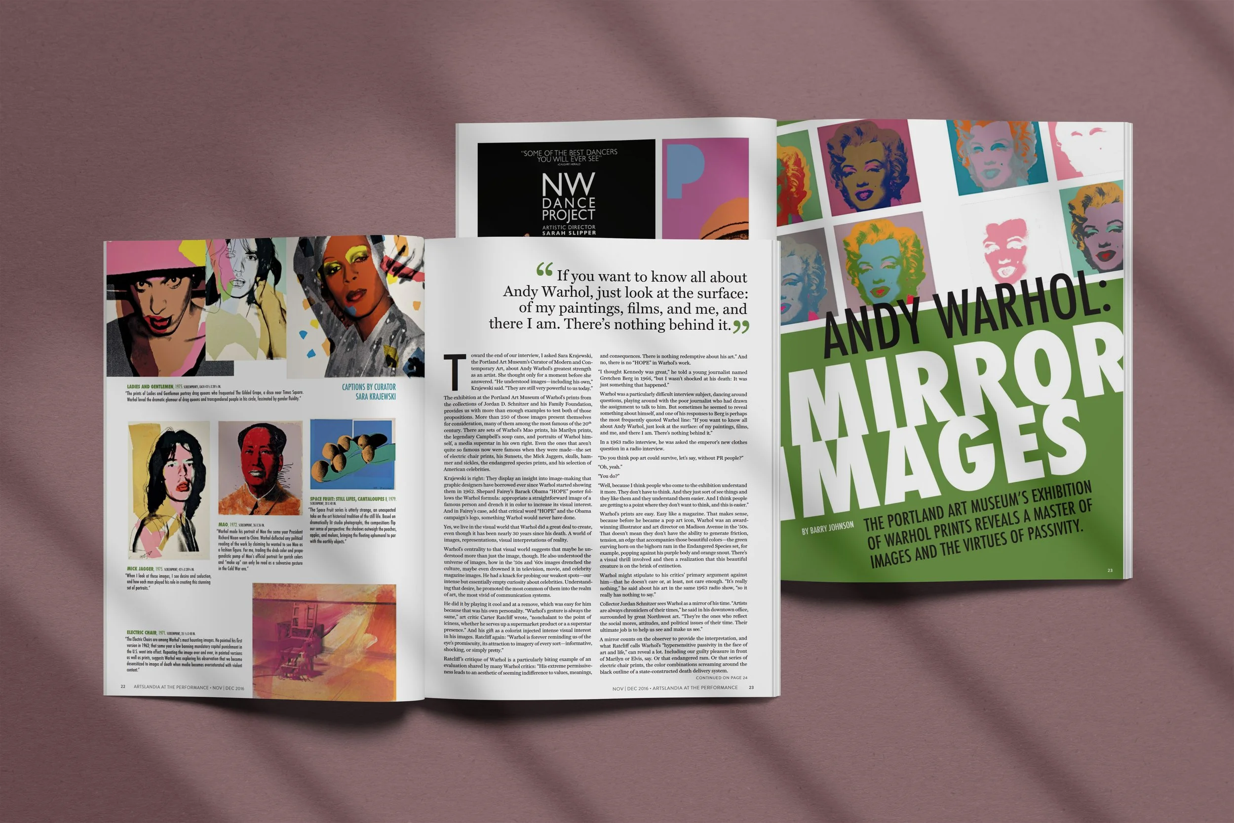Open magazine with article about Andy Warhol's mirror images art exhibition, featuring colorful pop art portraits of Marilyn Monroe and others, on a pink background with shadows.