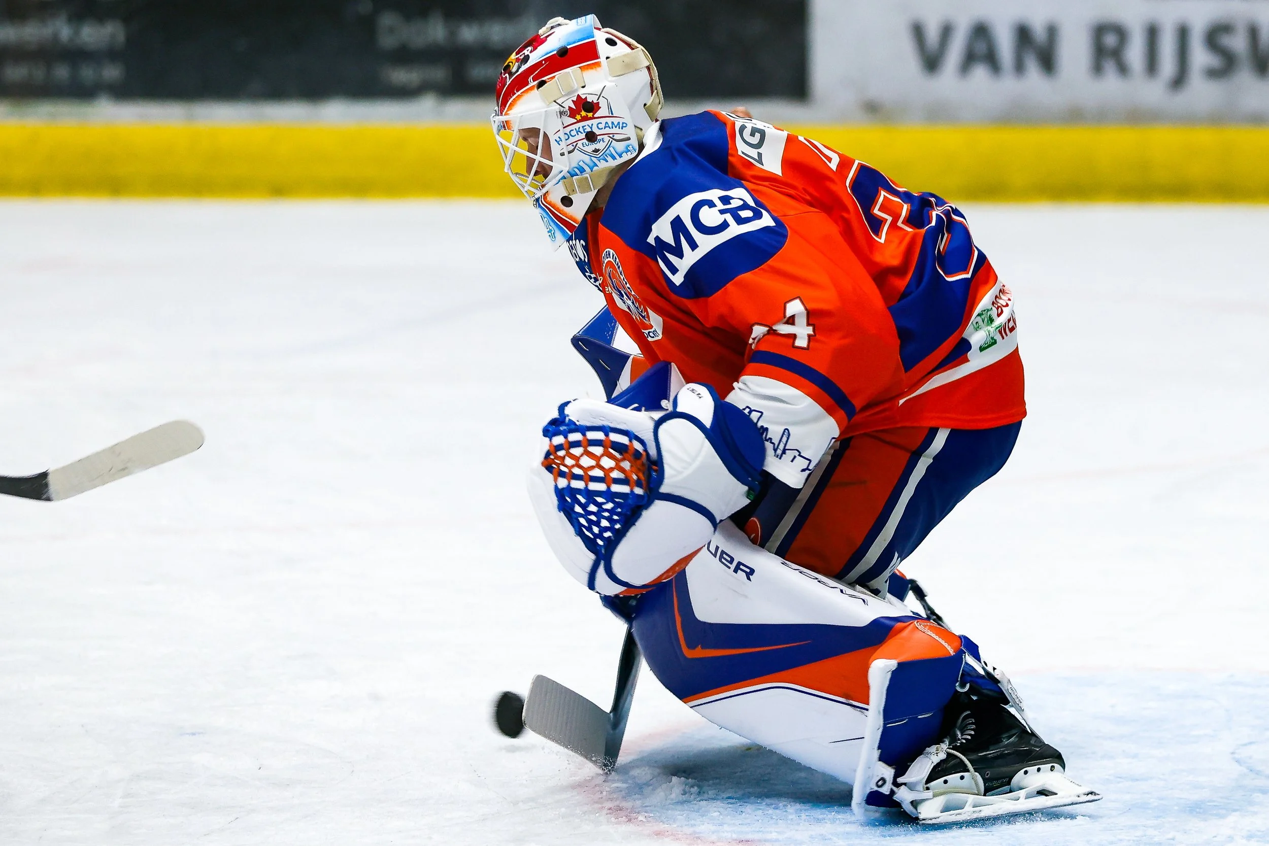 IJs-hockeykeeper in kleurrijk teamtenue tijdens wedstrijd op ijs. Kemphanen Eindhoven