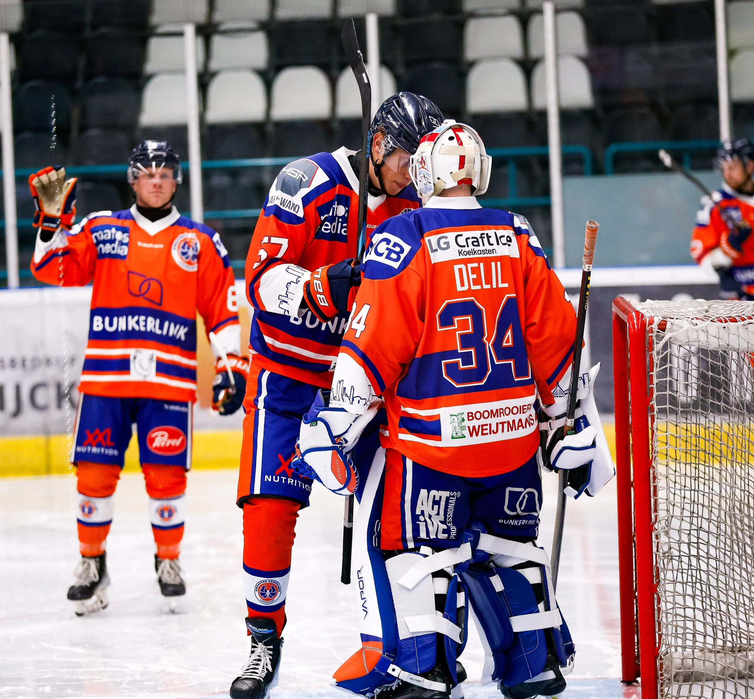 Hockeyspeelers in kleurrijke outfit met interactie op ijs. Eindhoven Kemphanen Icehockey