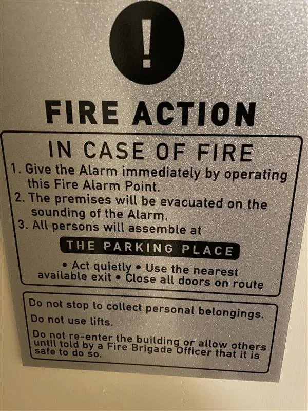 A fire alarm instruction sign.  It provides steps for evacuation during a fire.  The translation isn't accurate which may cause issues for guests.