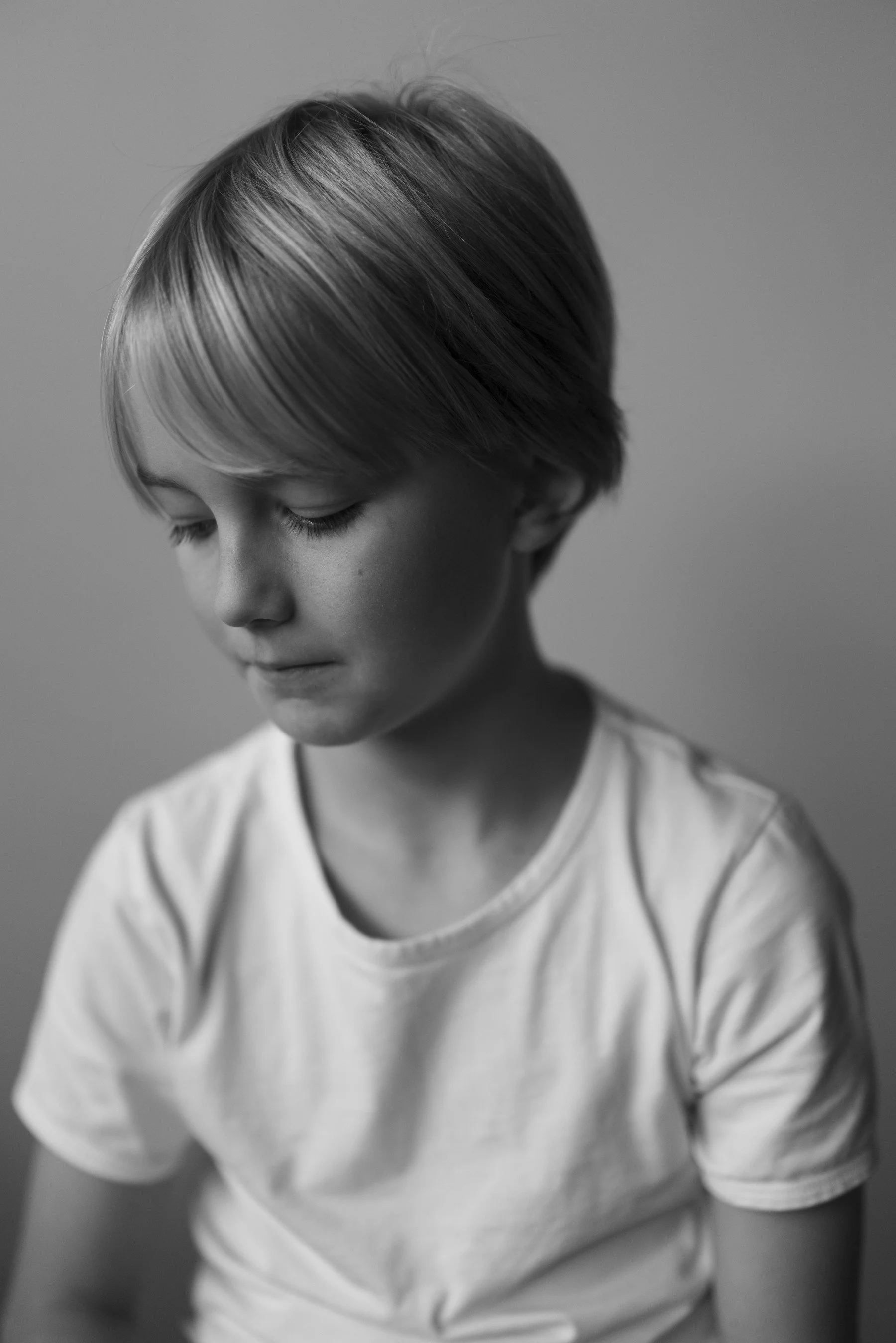 Black and white portrait of a child with short hair in soft light, photographed by Studio Trois Pommes