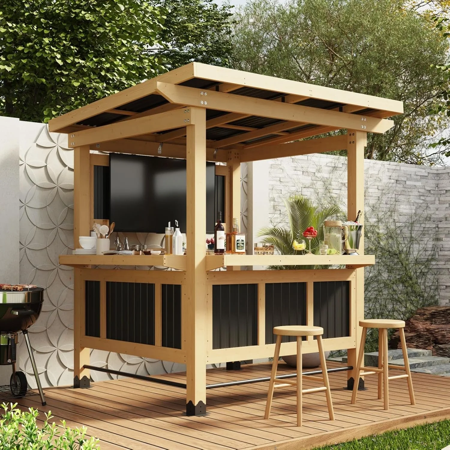 An outdoor bar area with a wooden structure, black panels, a flat-screen TV, and bar items on the counter. There are two light wooden stools, a small black grill, and greenery in the background.