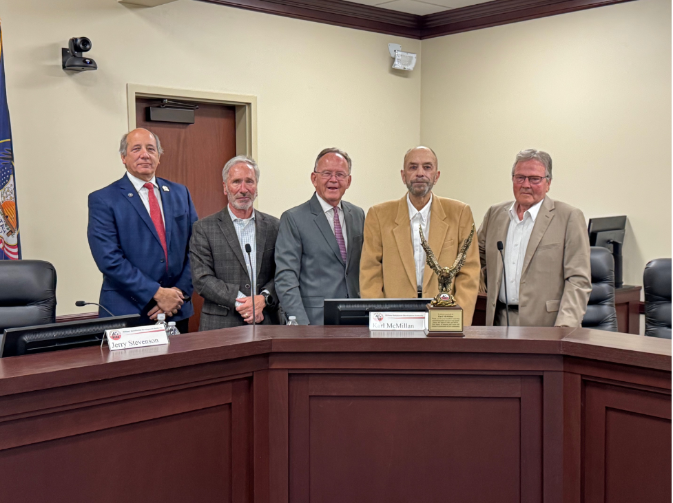 An image of the MIDA Board presenting a trophy to Karl McMillan.