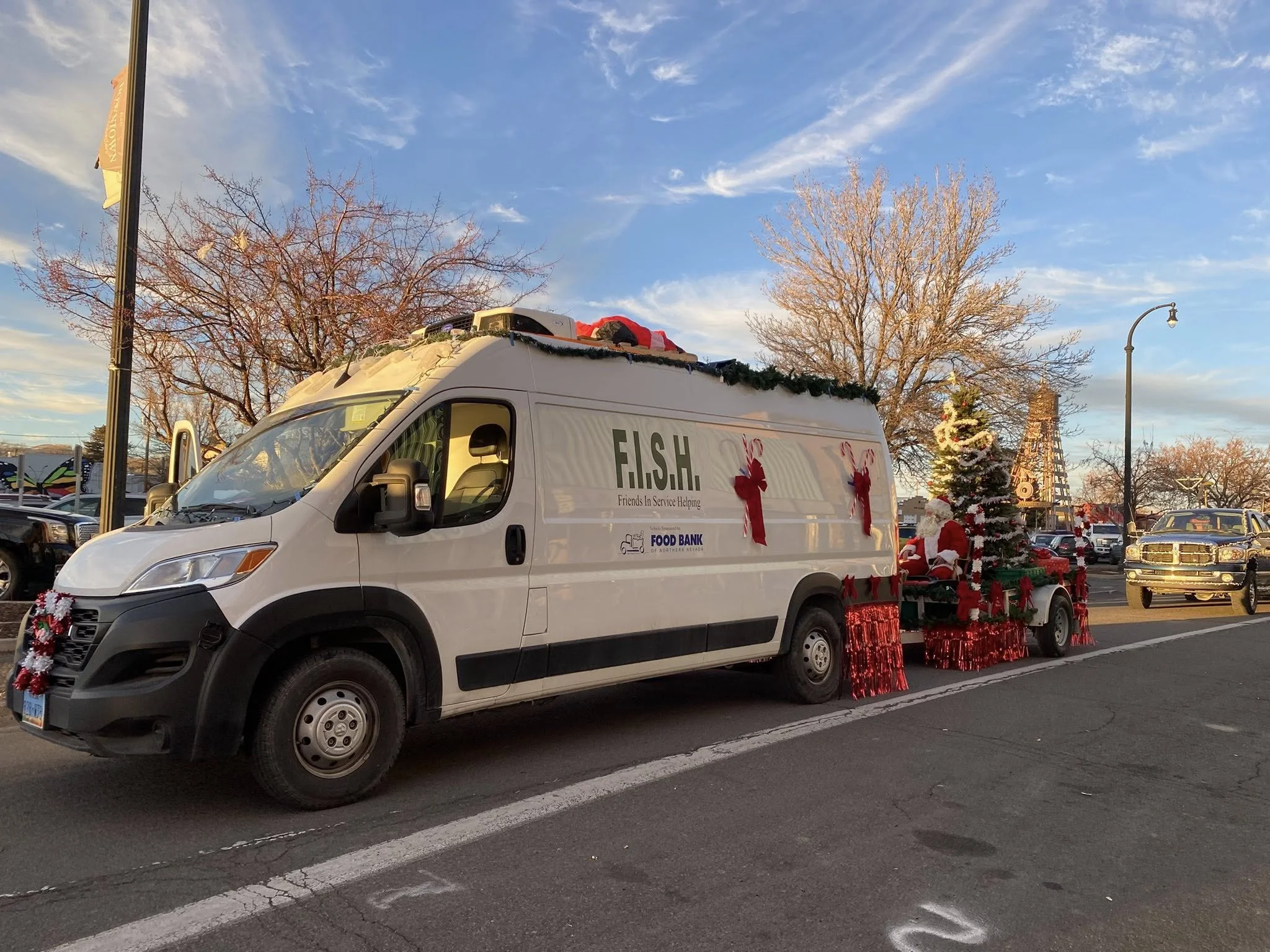 A decorated F.I.S.H. van and float participate in a community holiday parade.
