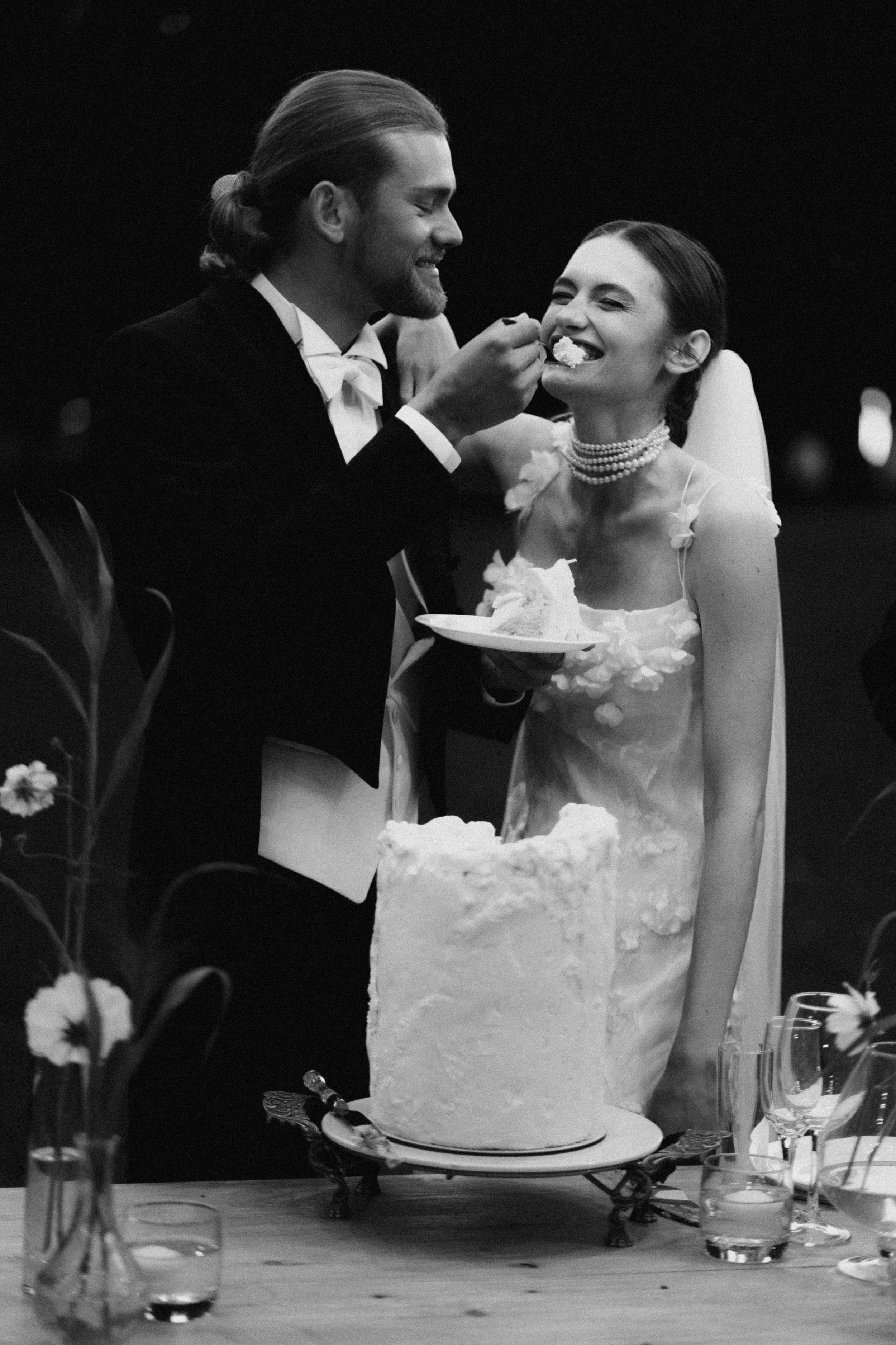 Bride and groom feeding each other wedding cake at a villa wedding at Tallichi Hill, Montenegro — fine art wedding photography