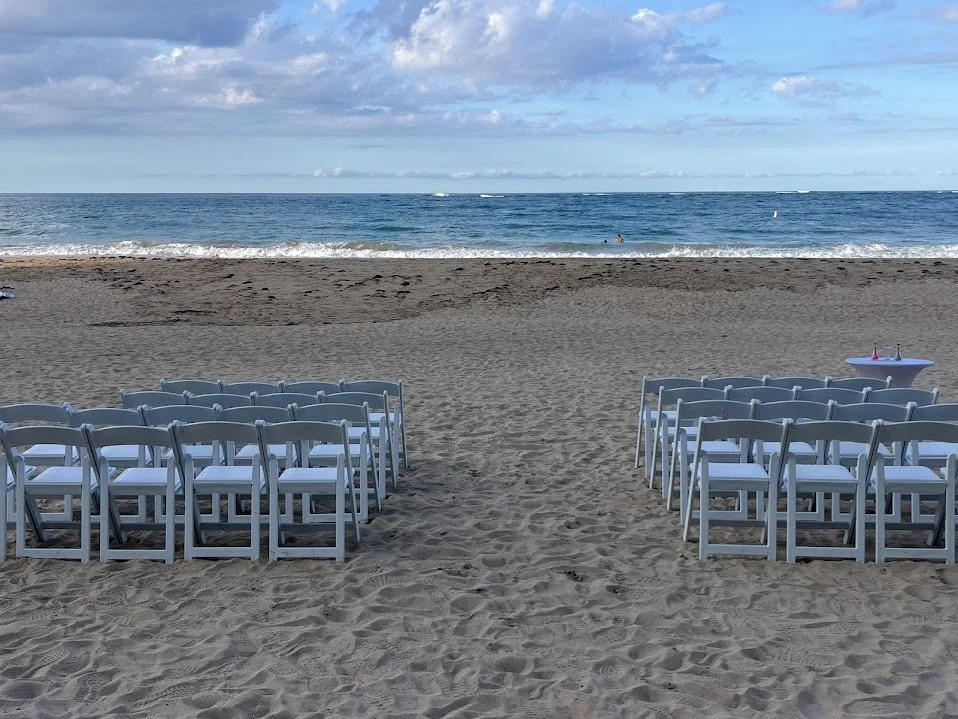 Elegant beach wedding ceremony setup with white chairs facing the ocean, ready for a luxury destination wedding in Puerto Rico.