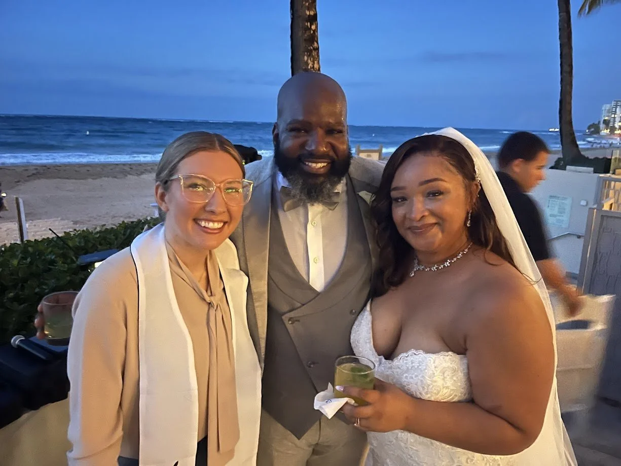 Paradise Vows PR owner Kendra smiling with a newly wed couple. 