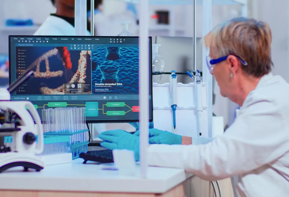 Scientist working in a laboratory with a computer displaying DNA double-stranded structure and genetic data