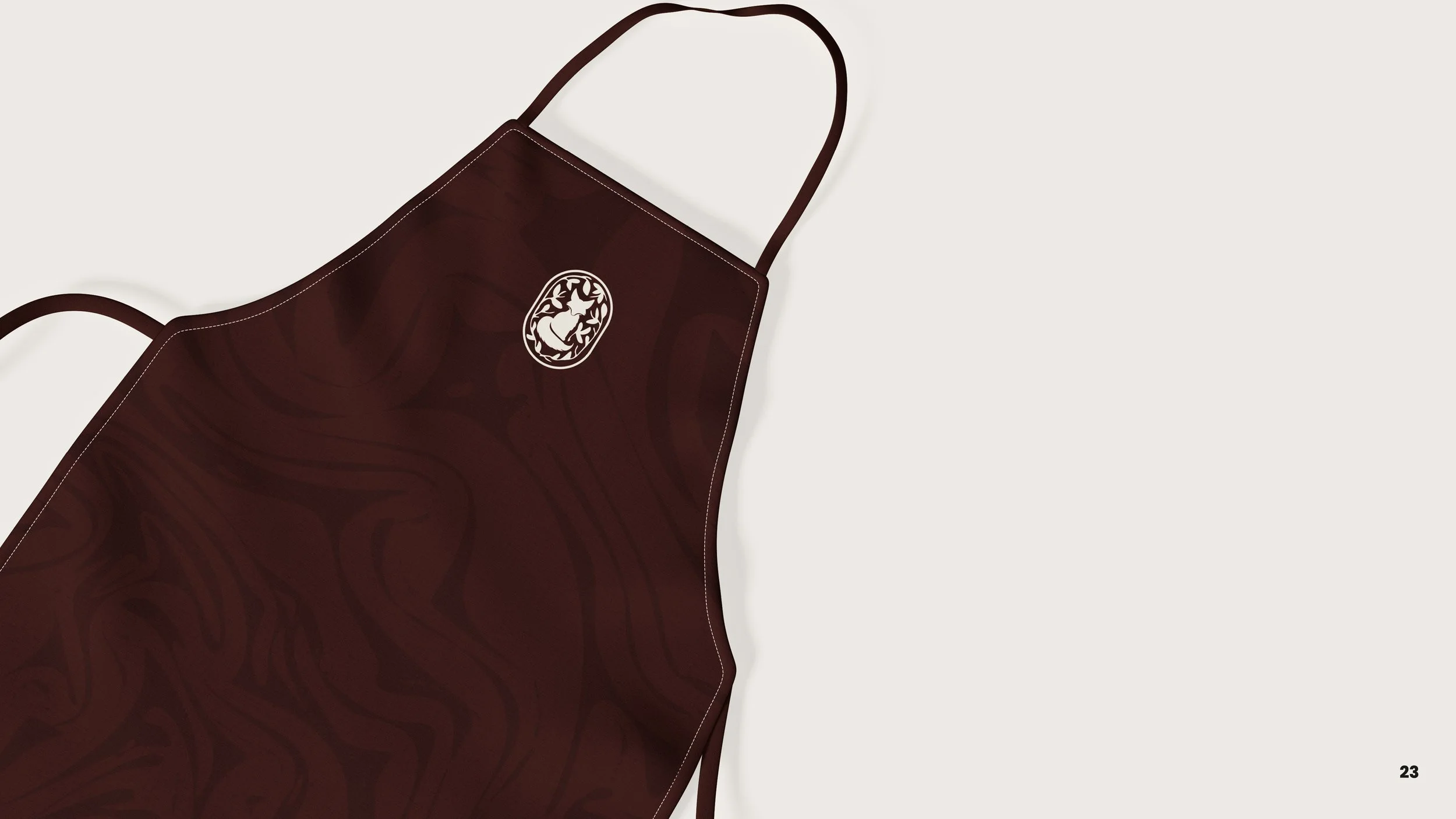 Maroon apron with a white logo of a rabbit in a circle, laid flat on a light background.