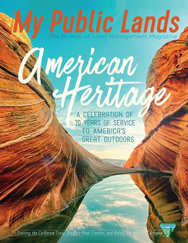 Cover of 'My Public Lands American Heritage' magazine featuring a landscape of colorful rock formations and a river, with text celebrating 70 years of service to America's outdoors.