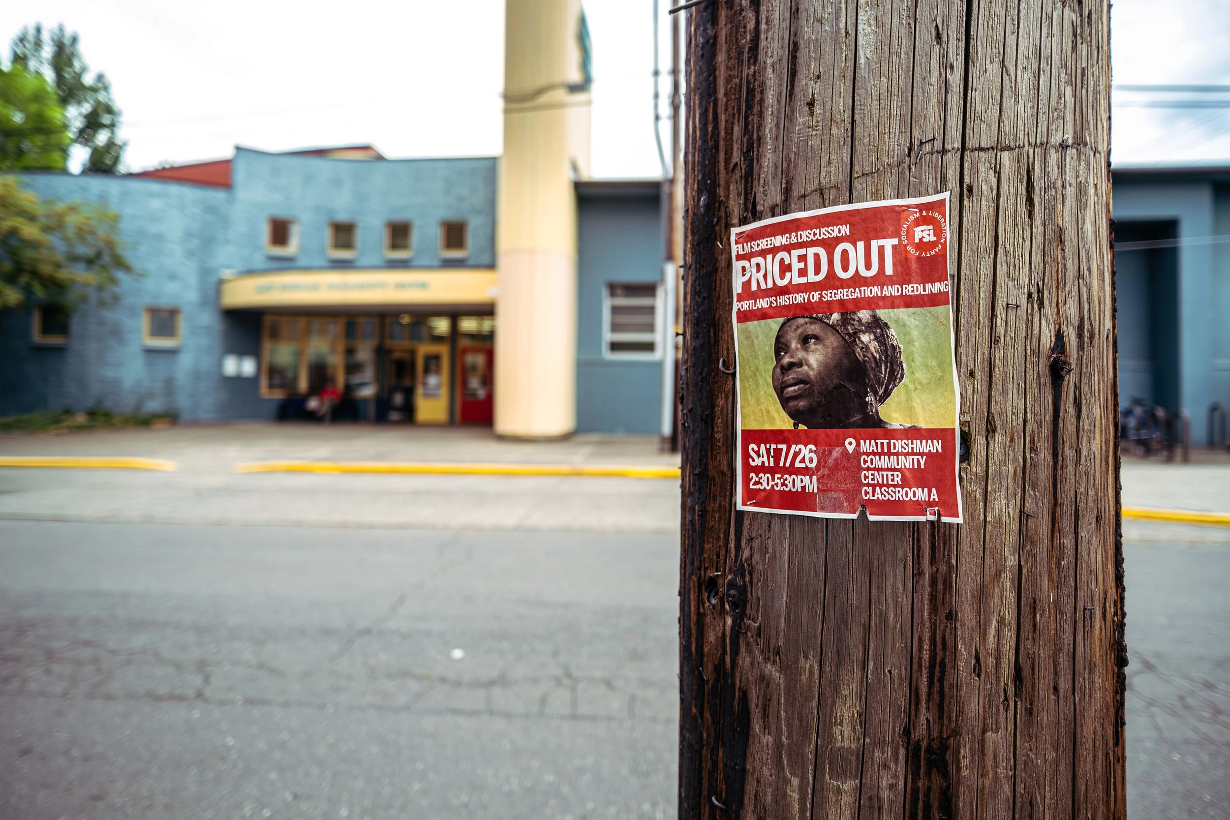 Poster on a wooden utility pole advertising a film screening and discussion about Portland's history of segregation and redlining, titled 'Priced Out', scheduled for Saturday, July 26th from 2:30 to 5:30 PM at Matt Dishman Community Center, Classroom