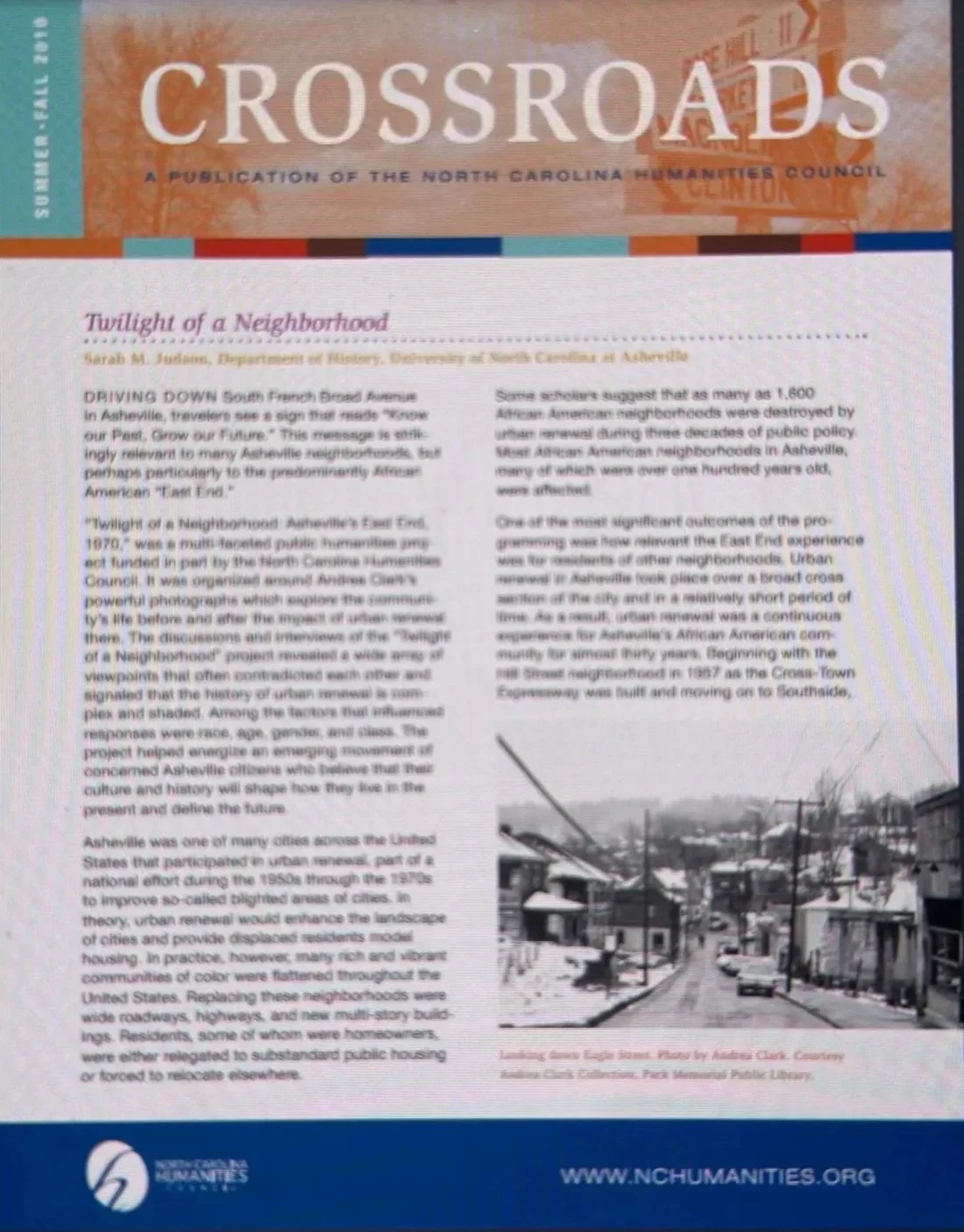 A magazine page titled "Crossroads" with an article about the neighborhood of Asheville, North Carolina, and a black-and-white photograph of a damaged street with fallen power lines.