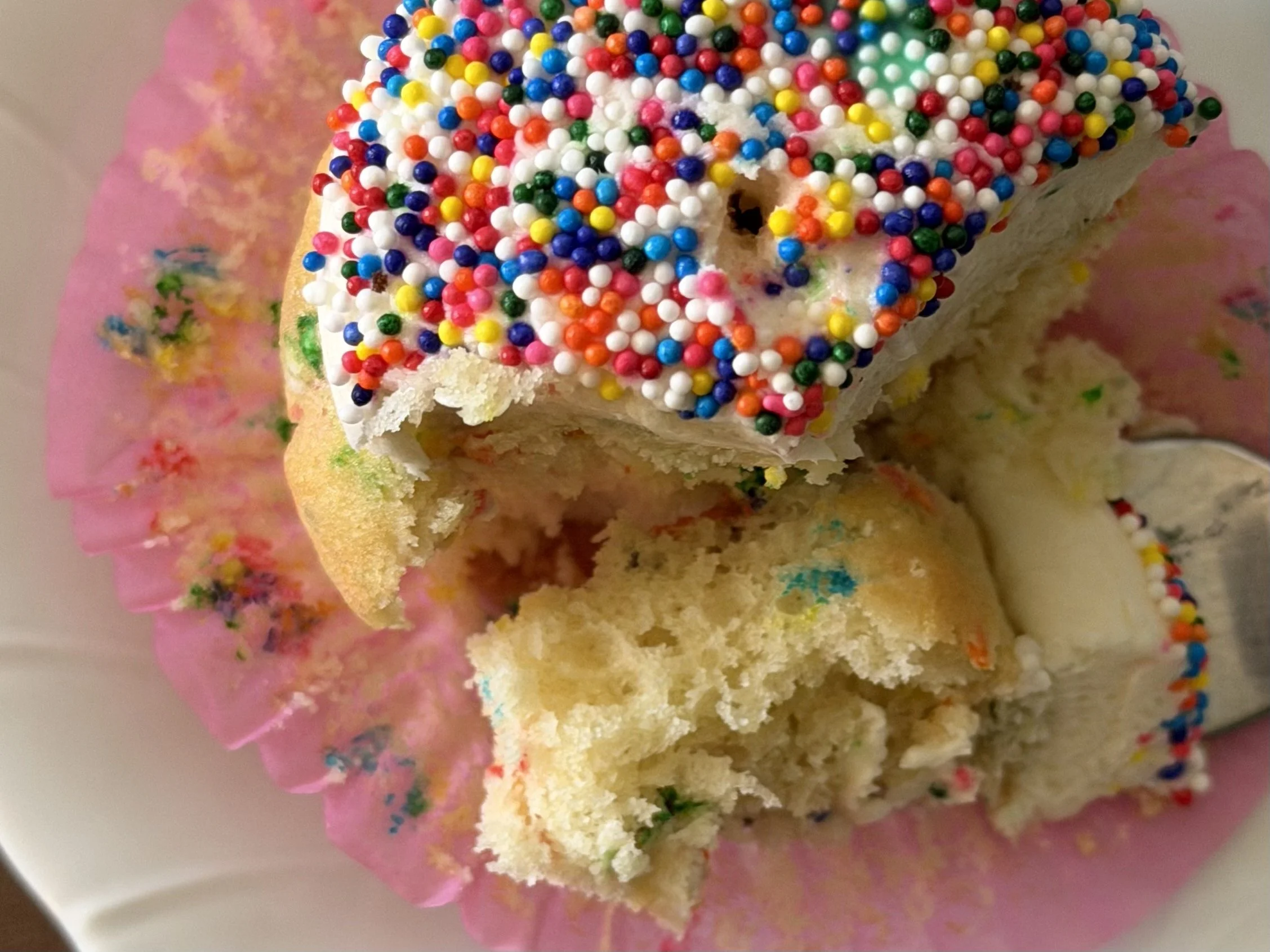 Celebrating five years in business with a confetti cupcake with sprinkles and a pink wrapper