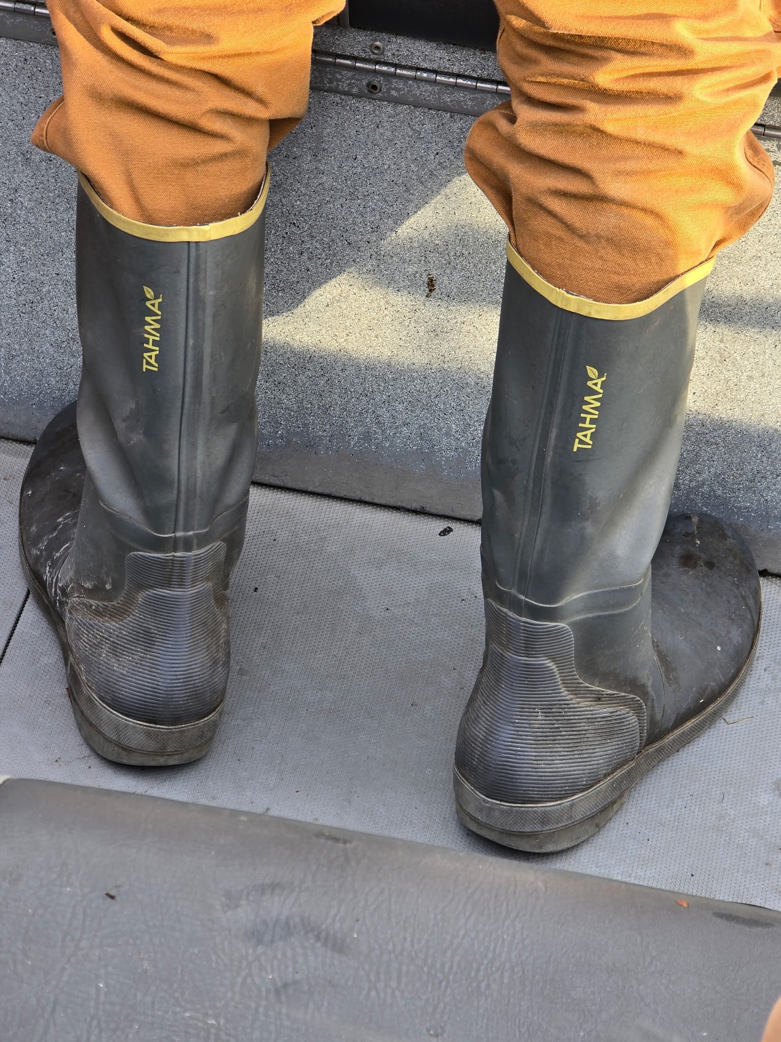 COmercial fisherman wearing Tahma tall boots on boat deck