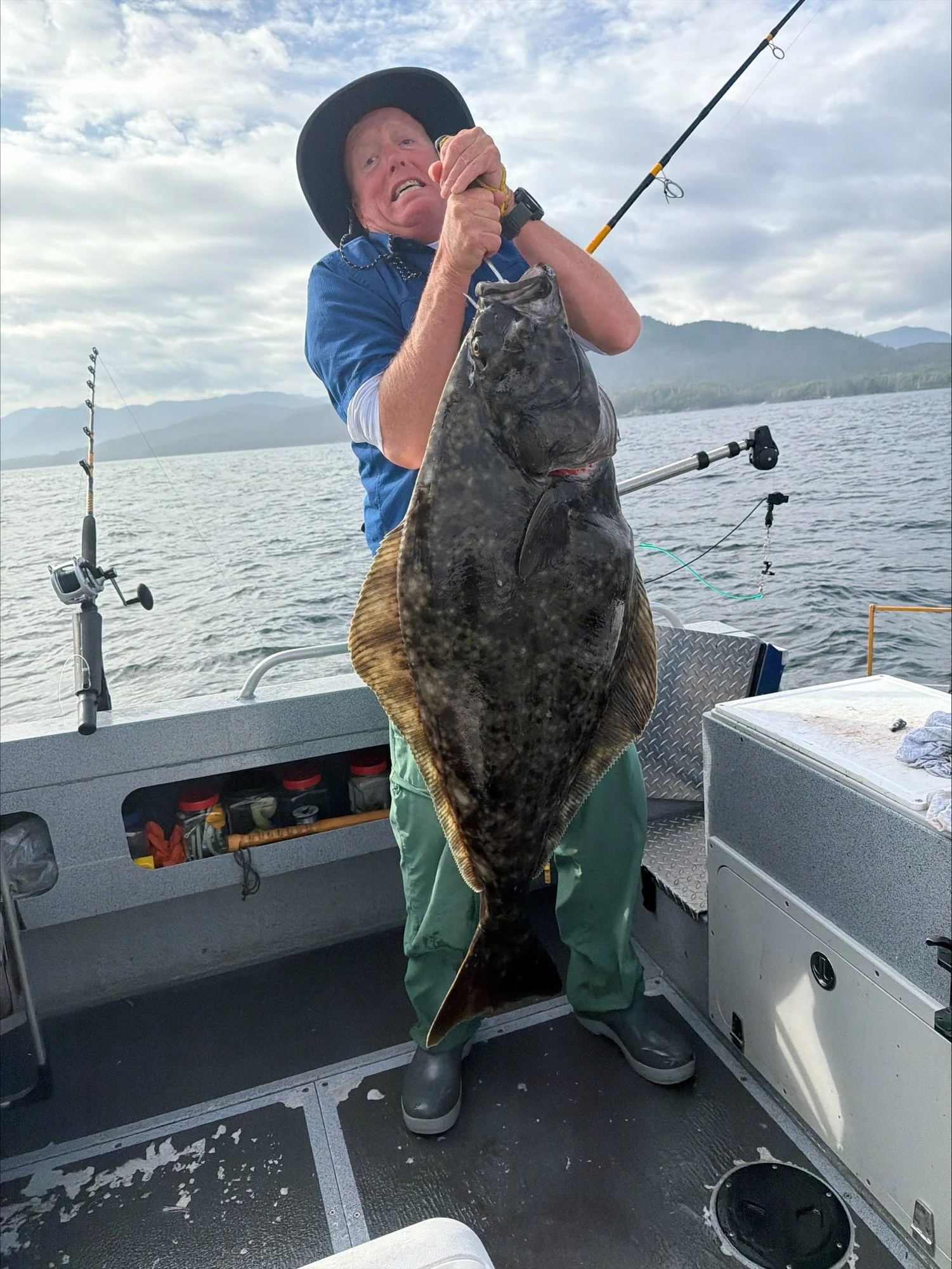 Tahma customer holding a huge fish caught off shore on a boat